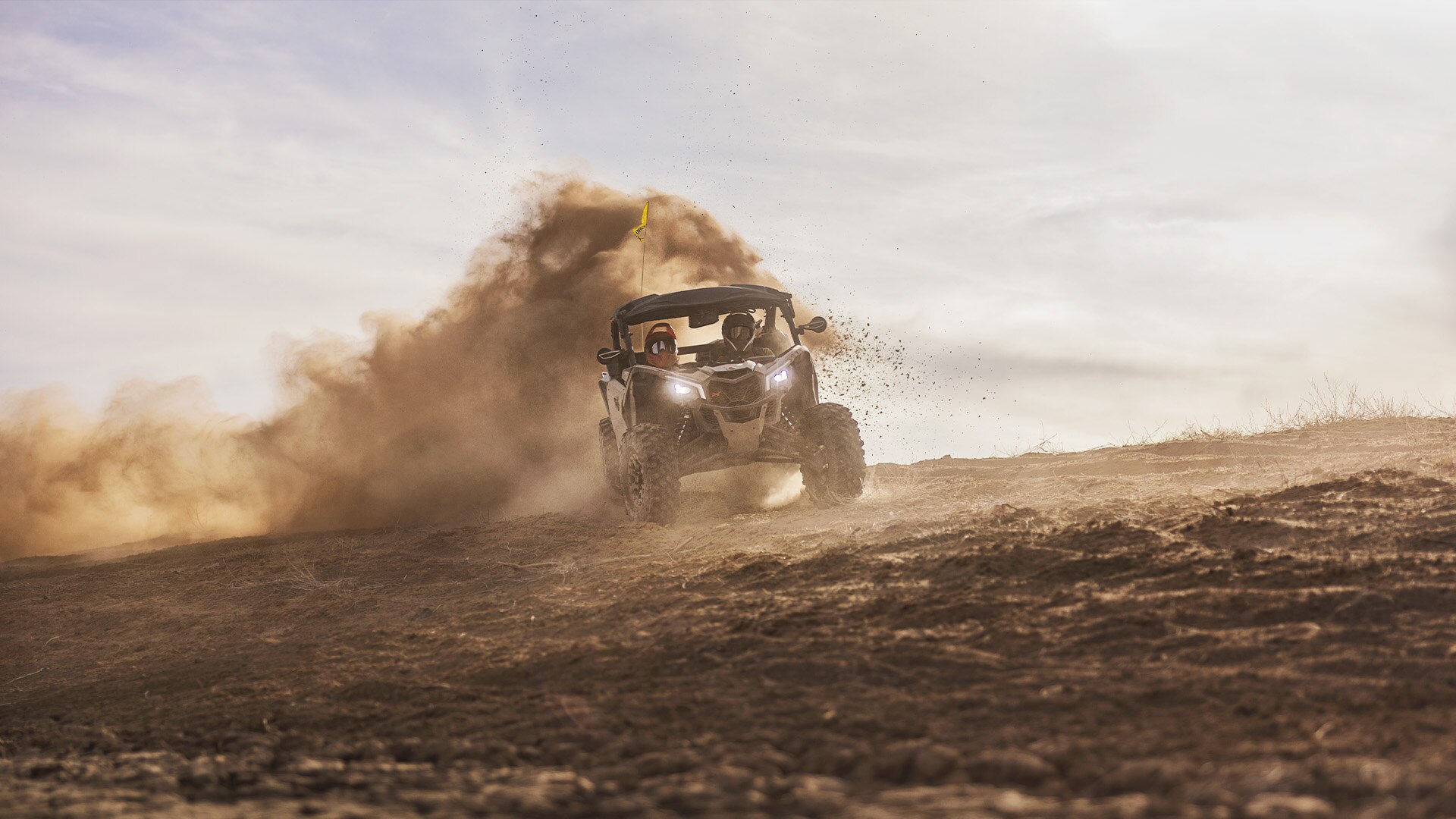 Can-Am SxS vehicle riding in the dirt at high speed