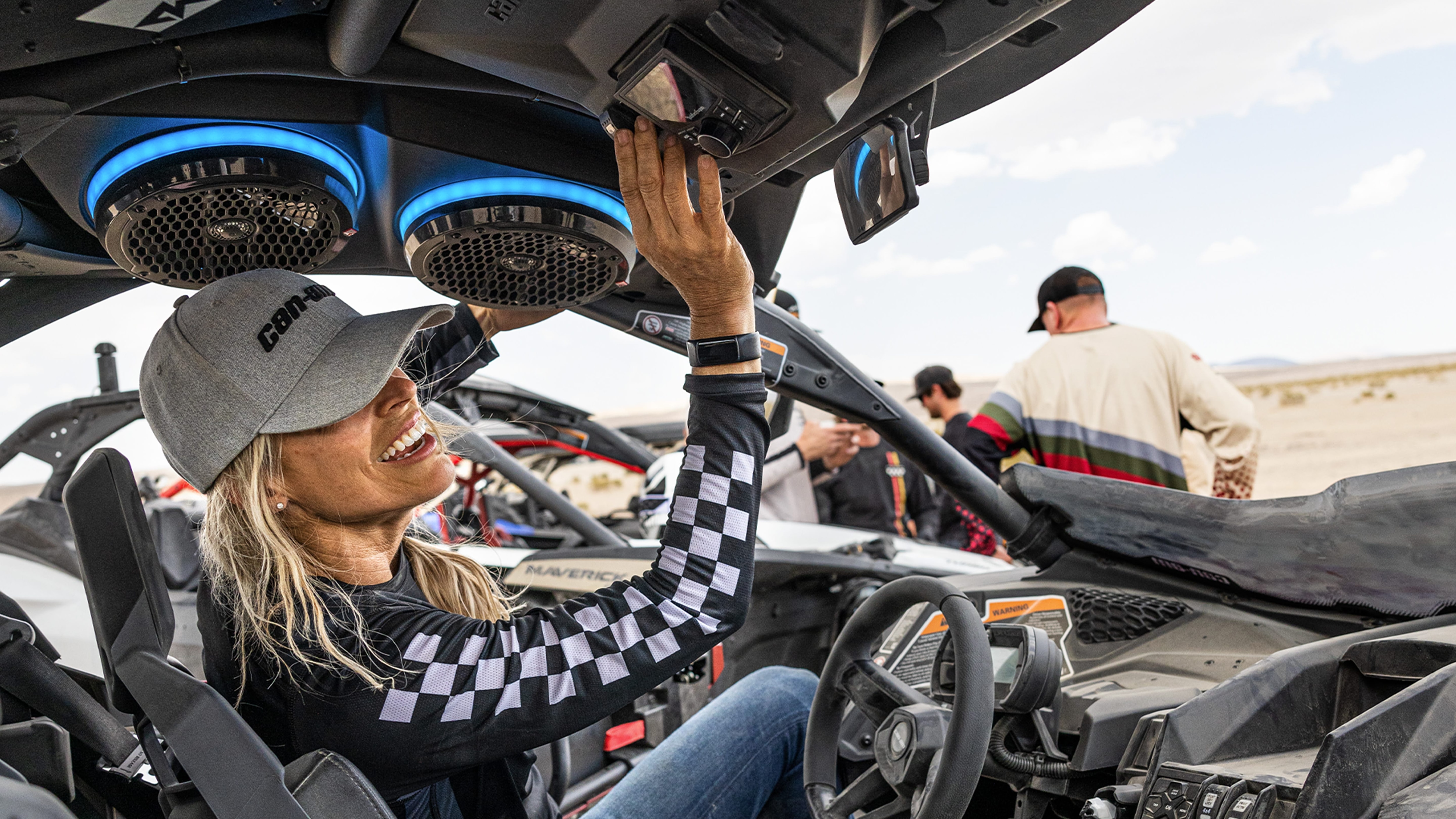 Woman using the sound system of a Can-Am Side-by-side vehicle
