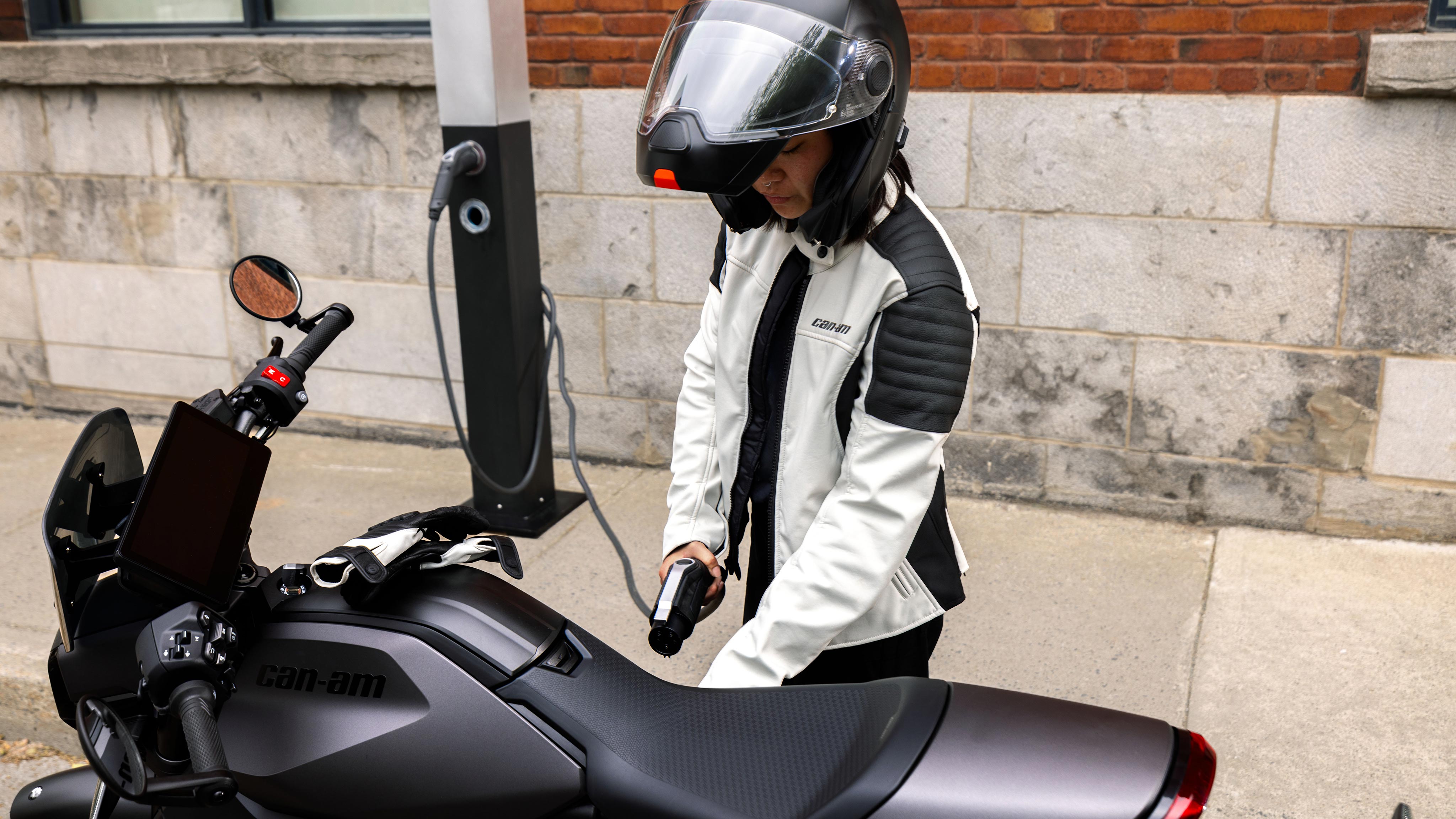 Female driver ready to charge her Can-Am electric motorcycle