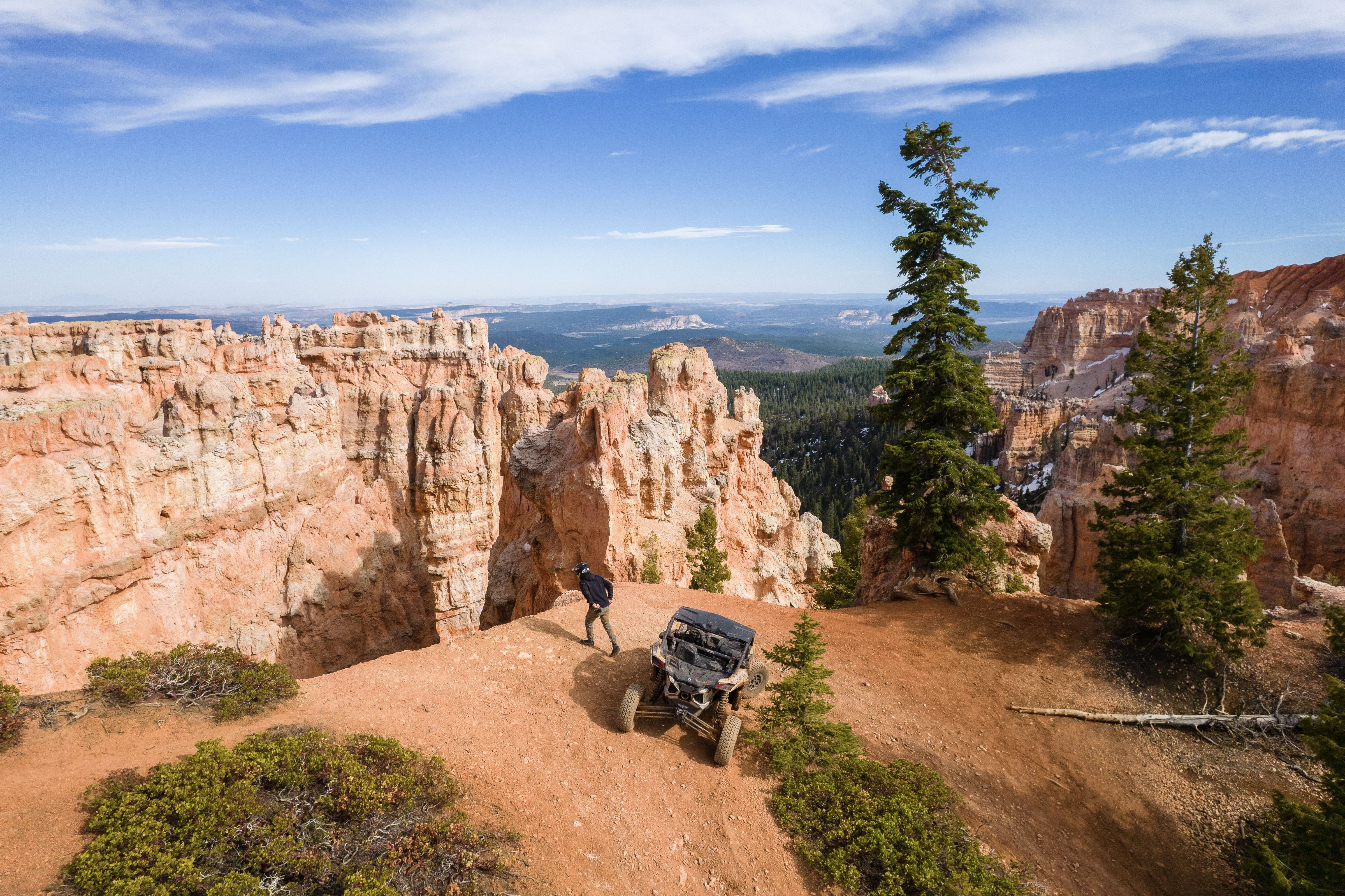 driver outside an off-road vehicle overlooking a mountainous view