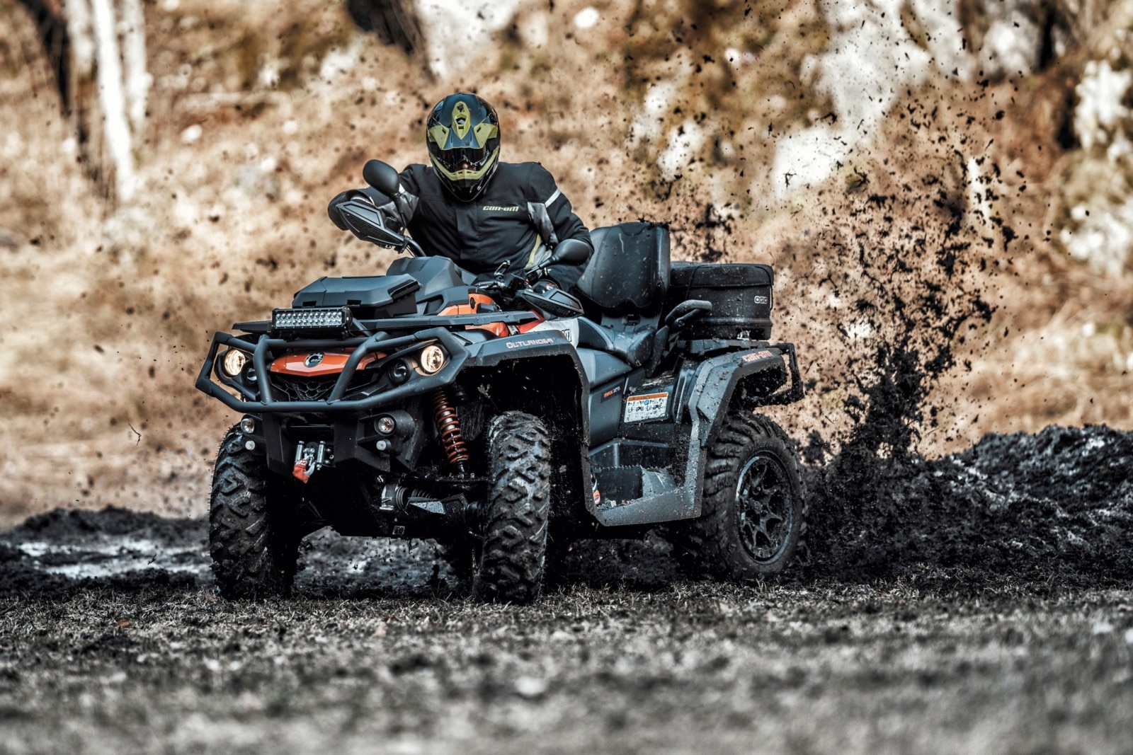 An ATV riding in a muddy trail