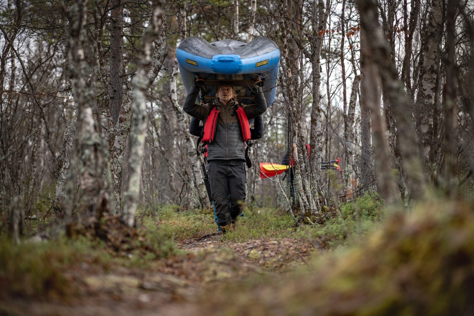 Jukka and Jarppi carry a canoe