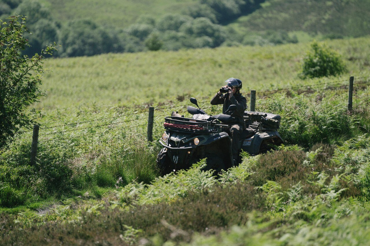 A man with binoculars on an ATV