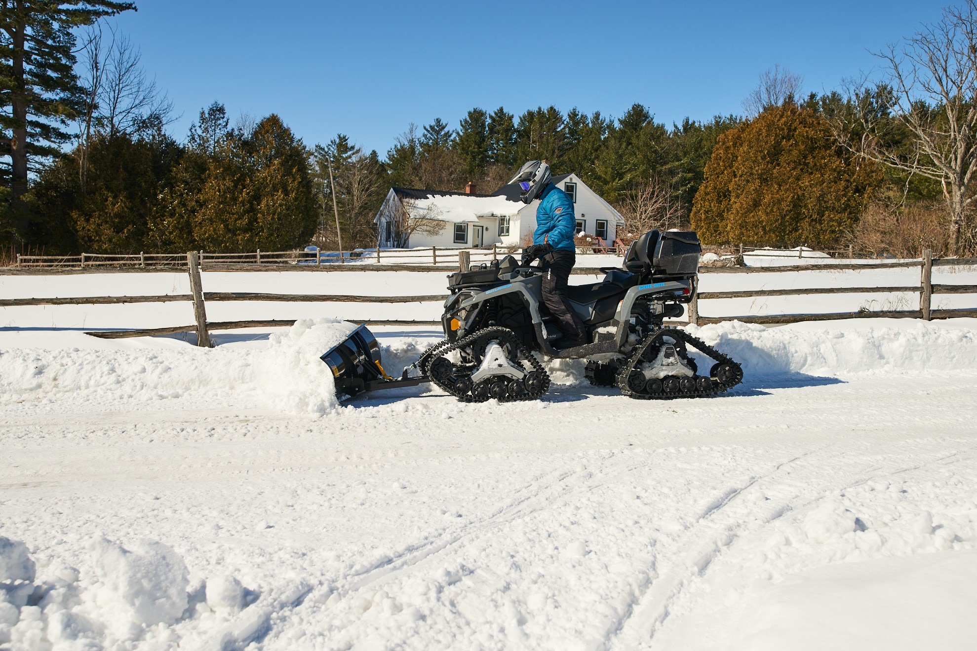 Traxter plogar snö med bandsats