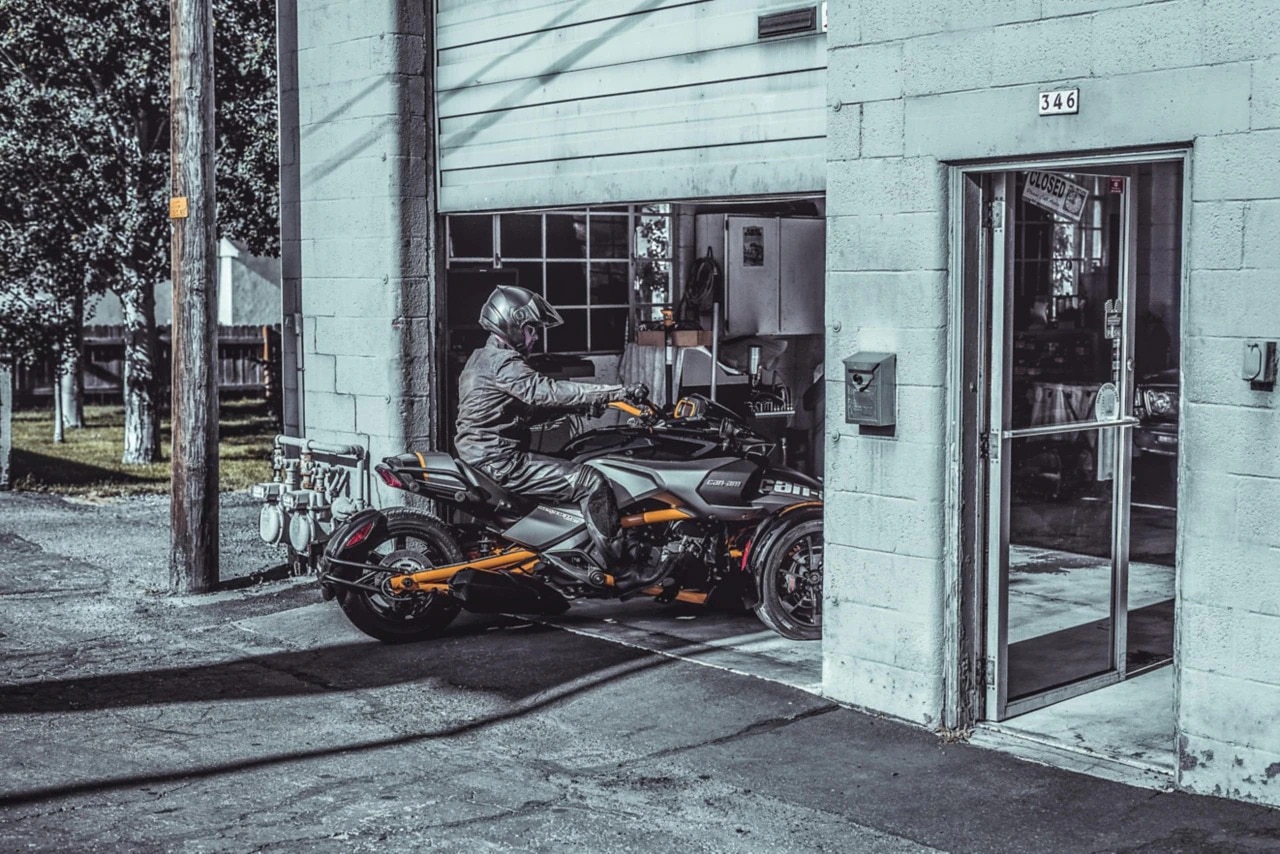 Man riding his Spyder into a garage