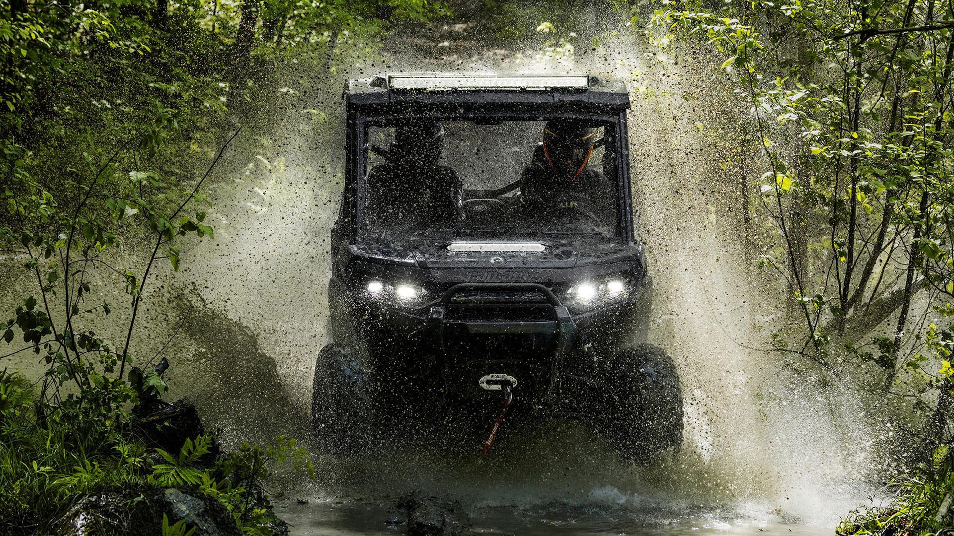 2026 Can-Am Traxter SxS riding through a puddle