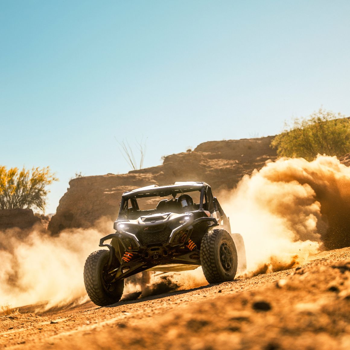Ein Can-Am Maverick X RS Side-by-Side-Fahrzeug fährt in der Wüste und hinterlässt eine Staubwolke