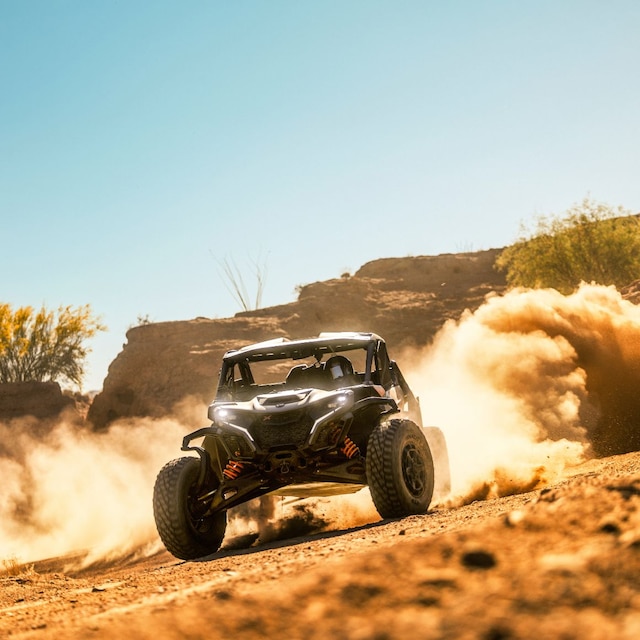 Ein Can-Am Maverick X RS Side-by-Side-Fahrzeug fährt in der Wüste und hinterlässt eine Staubwolke