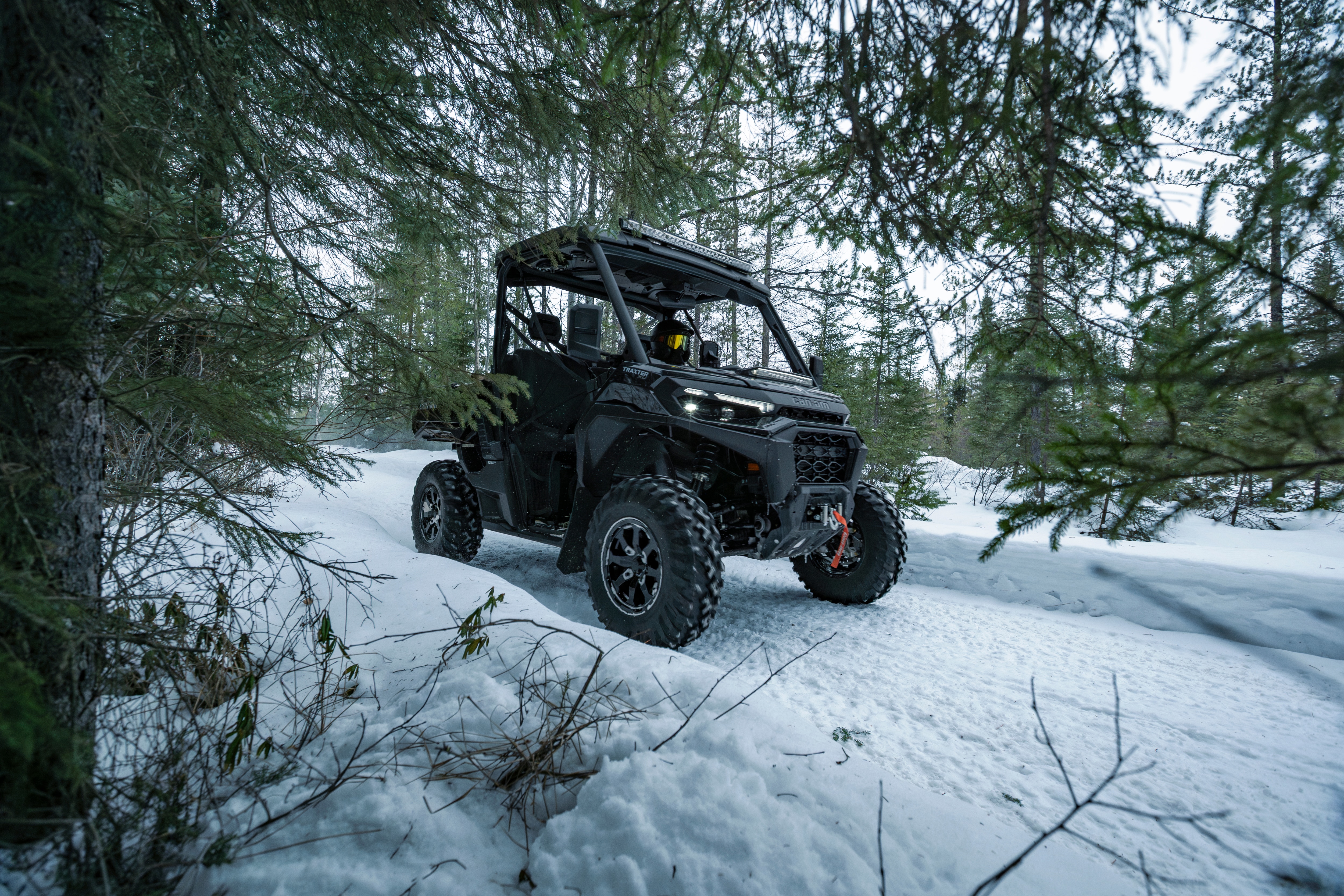 Un Can-Am Traxter XU HD1 roulant sur un sentier enneigé
