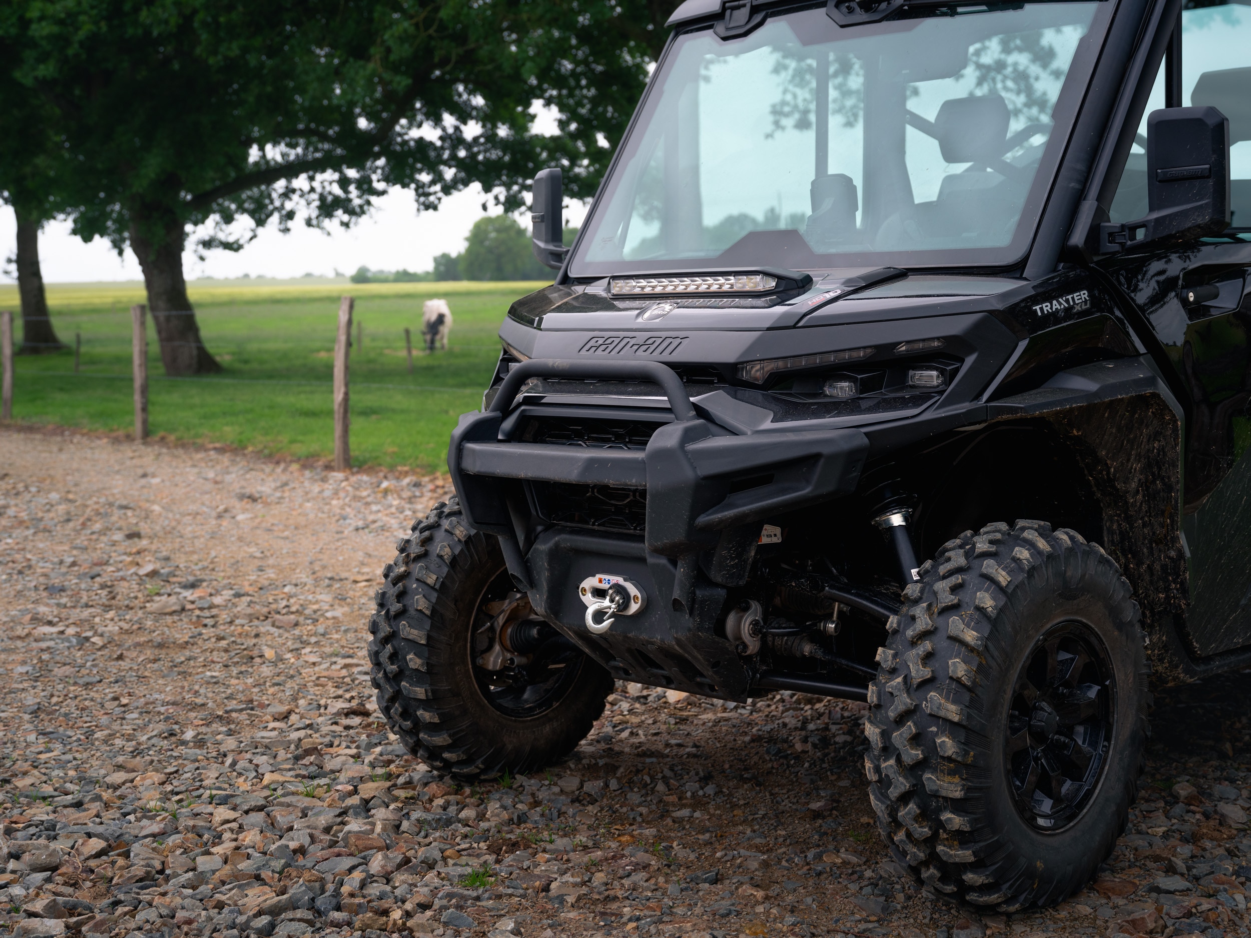 Can-Am Traxter XU geparkeerd op een onverharde weg naast een veld