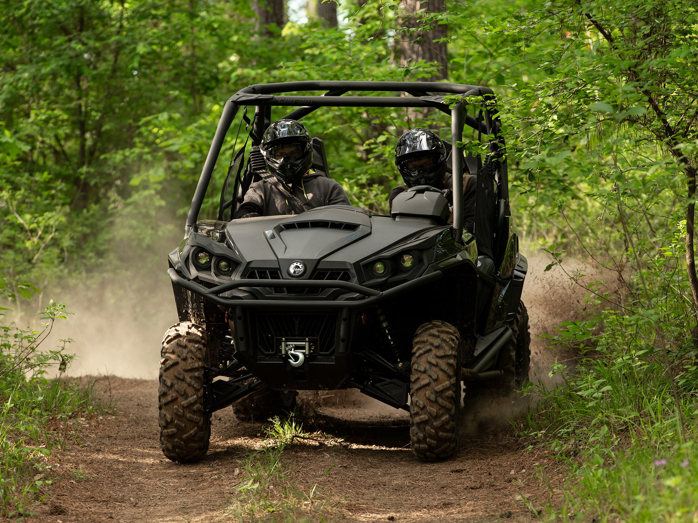Two people in a black Can-Am Commander side-by-side