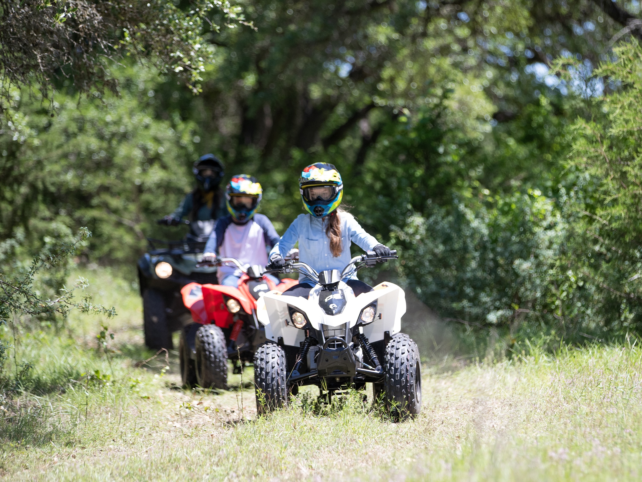 Three kids riding their Can-Am Off-Road DS ATVs