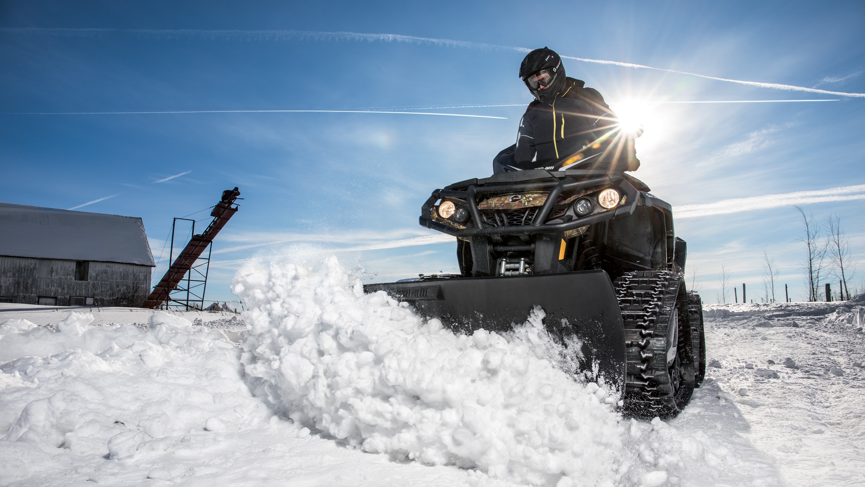 Man snow plowing with a Can-Am Promount plow on a Can-Am Outlander ATV
