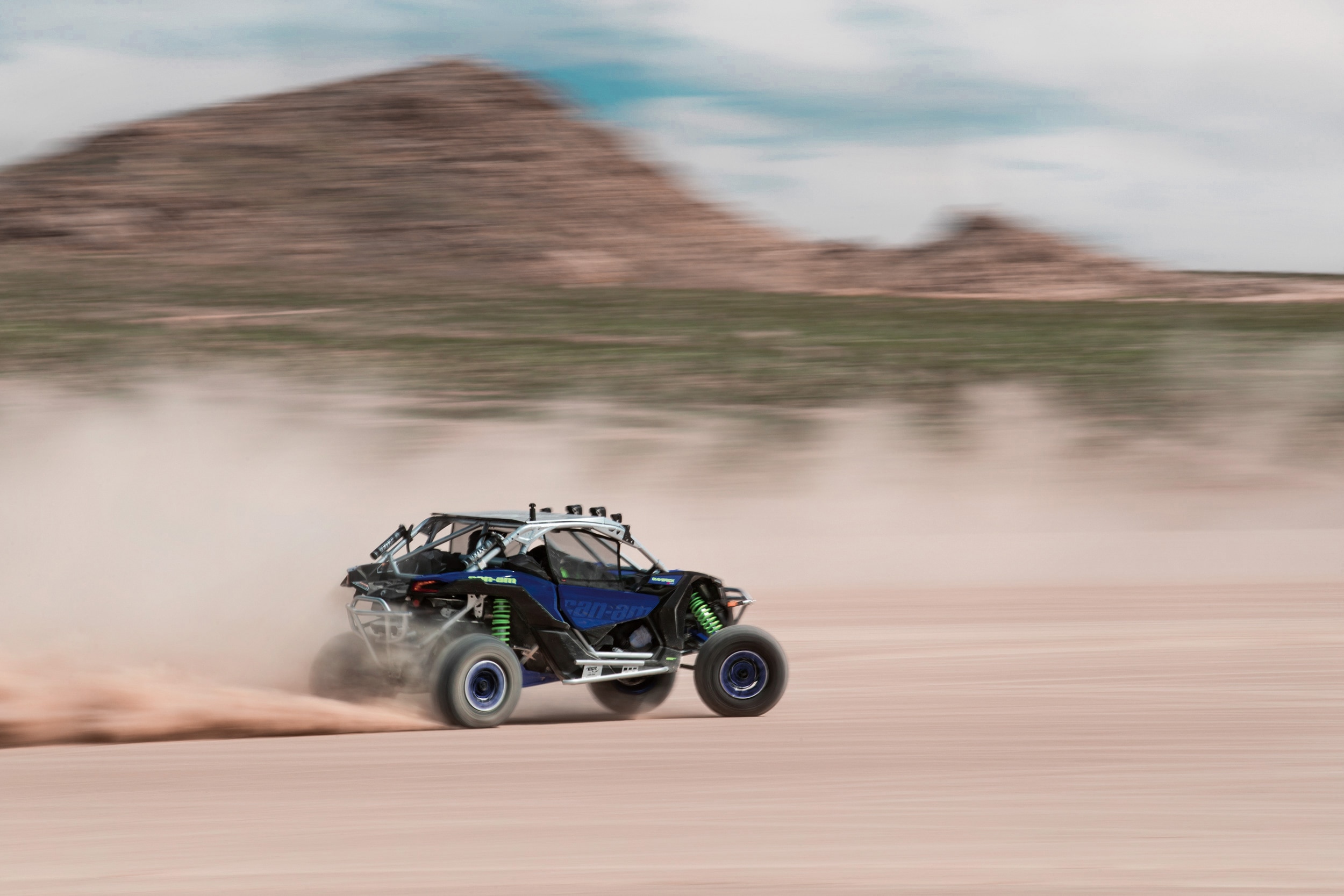 A Can-Am Maverick X3 X rs side-by-side at full speed in the desert