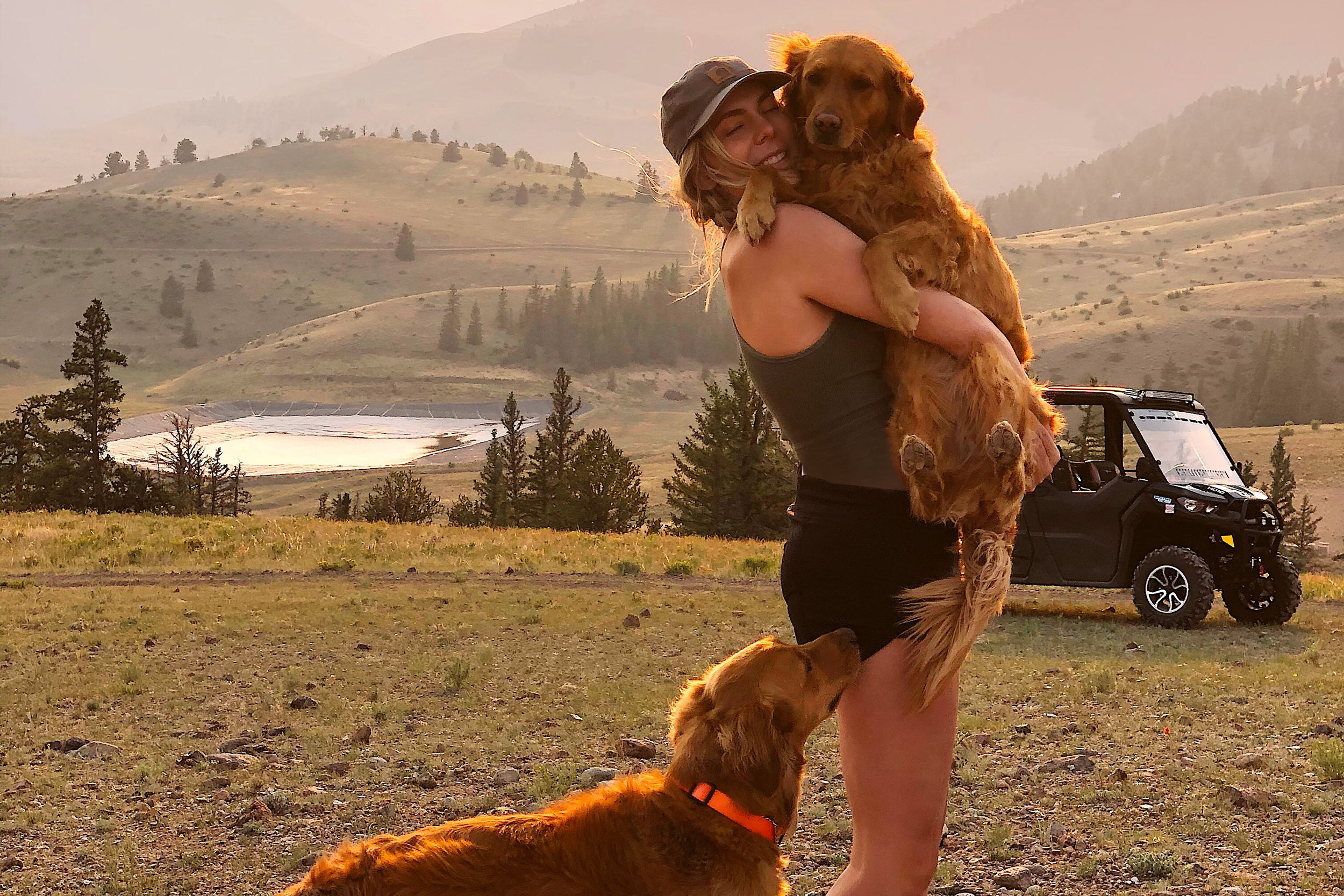 Claire Gierke abrazando a uno de sus dos perros cerca de su Can-Am Defender Lone Star