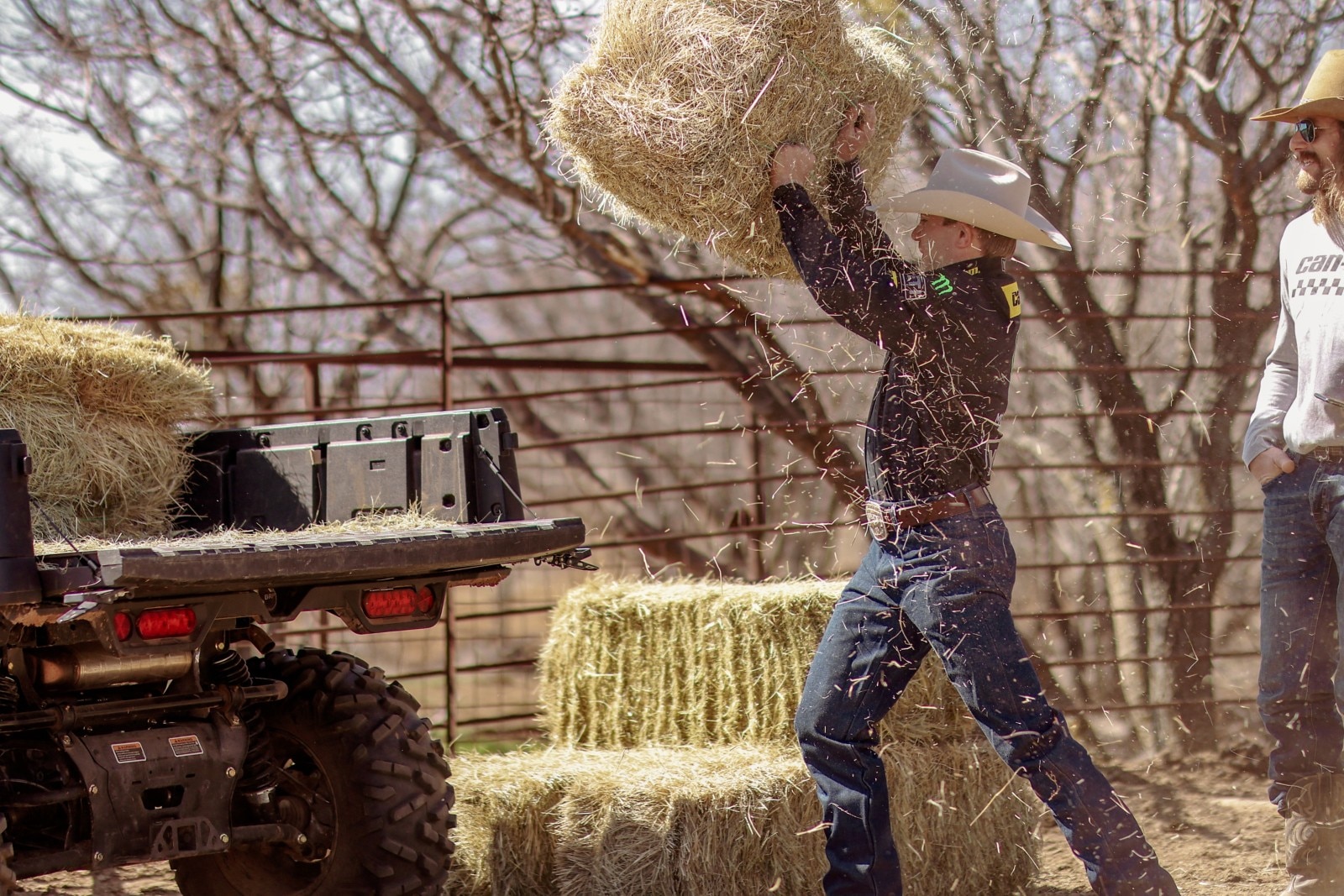 A rider transporting hay in a Defender