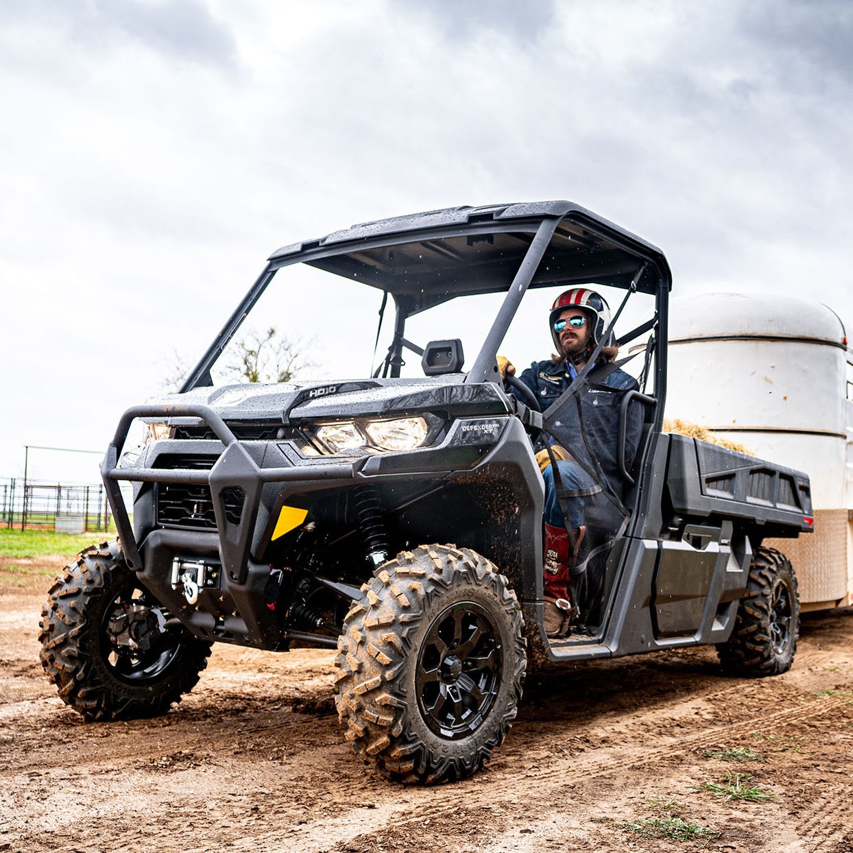 Man riding a Can-Am Defender at the farm
