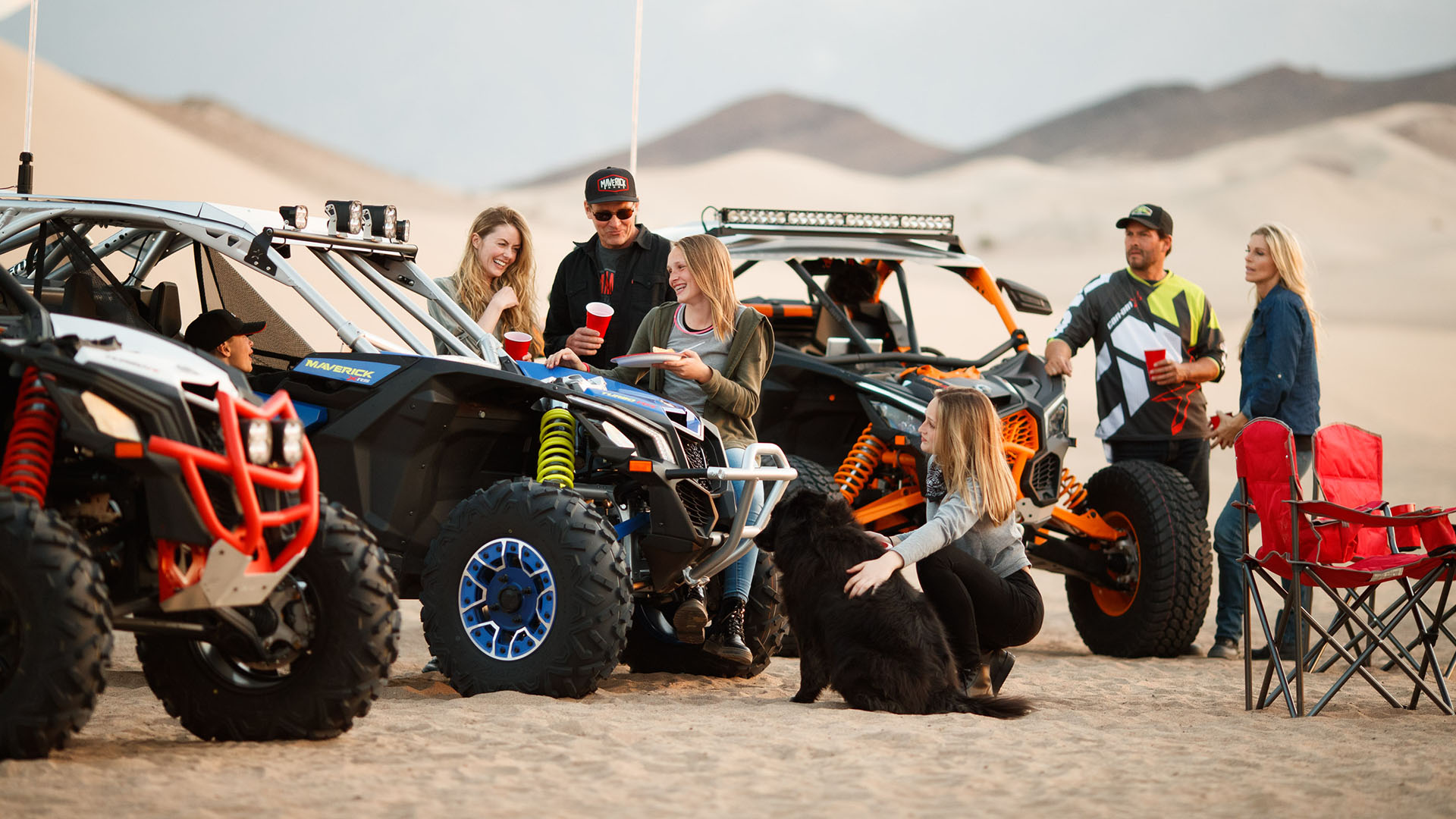 Un grupo de personas y vehículos Can-Am side-by-side en el desierto