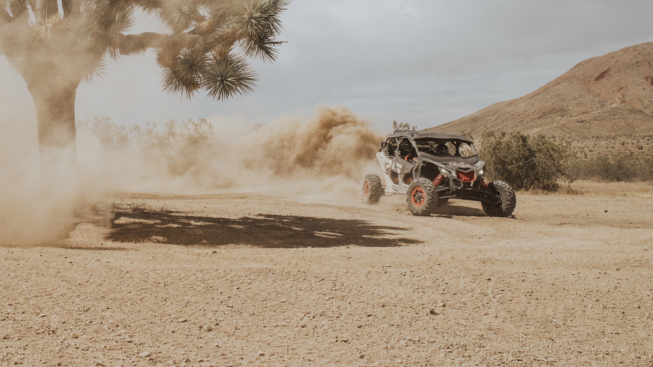 Un vehículo ligero de dos plazas (SxS) Can-Am Off-Road levantando polvo por el desierto
