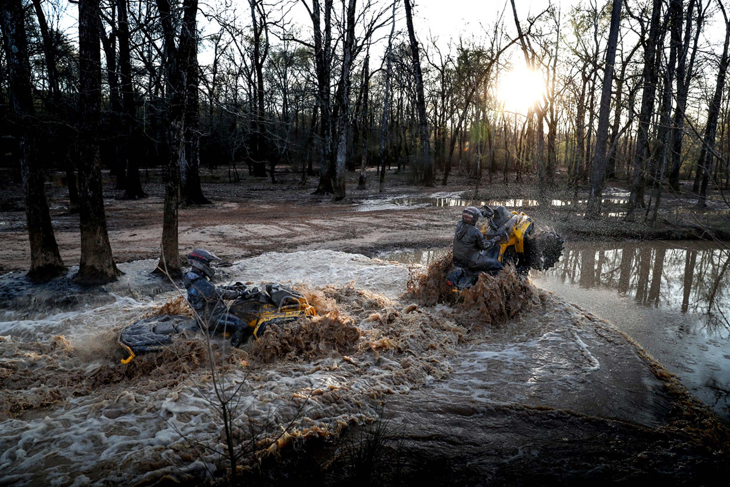 Two people riding in mud with their Can-Am Outlander X mr ATV