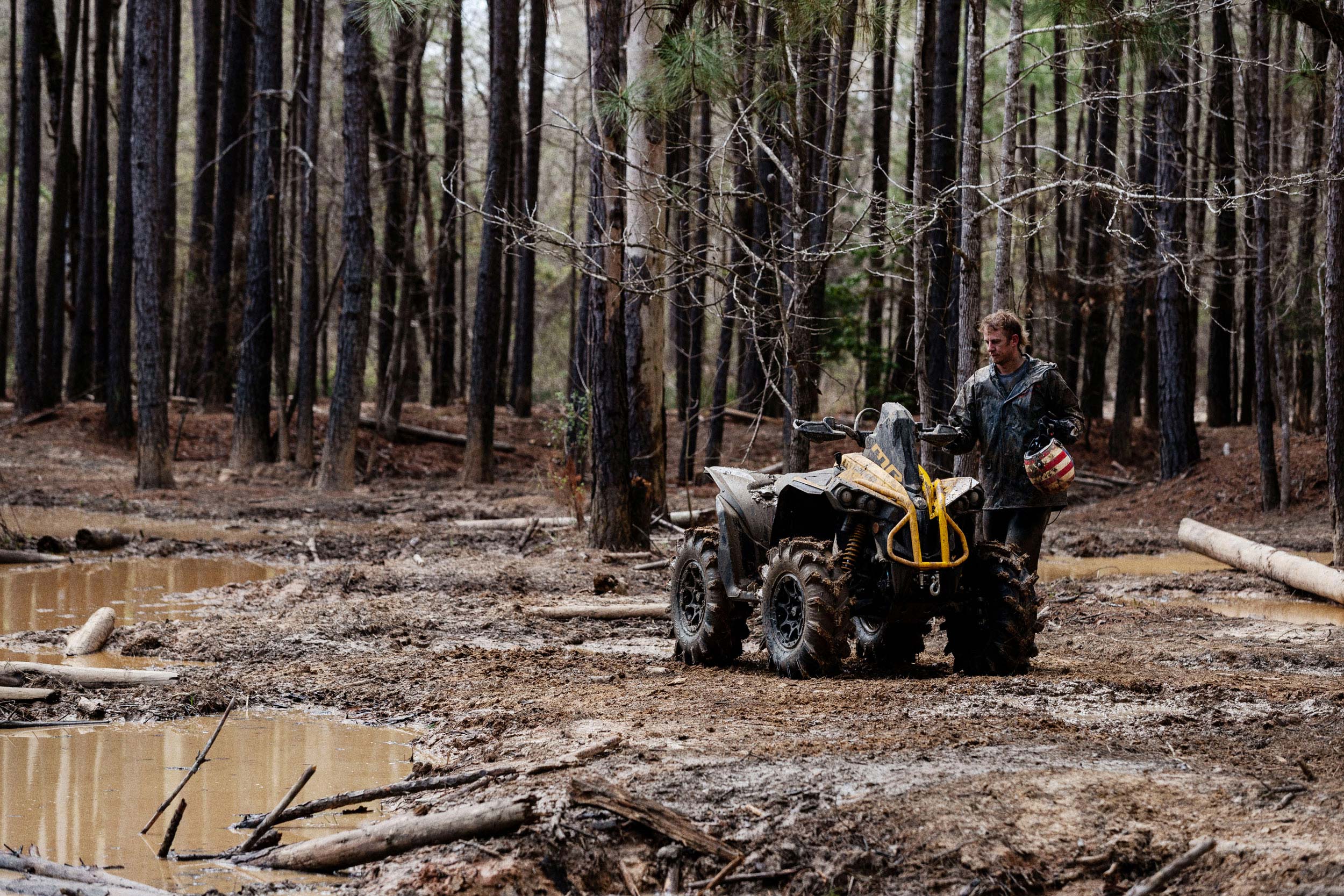 A man and a Can-Am Renegade X mr 1000 in the mud