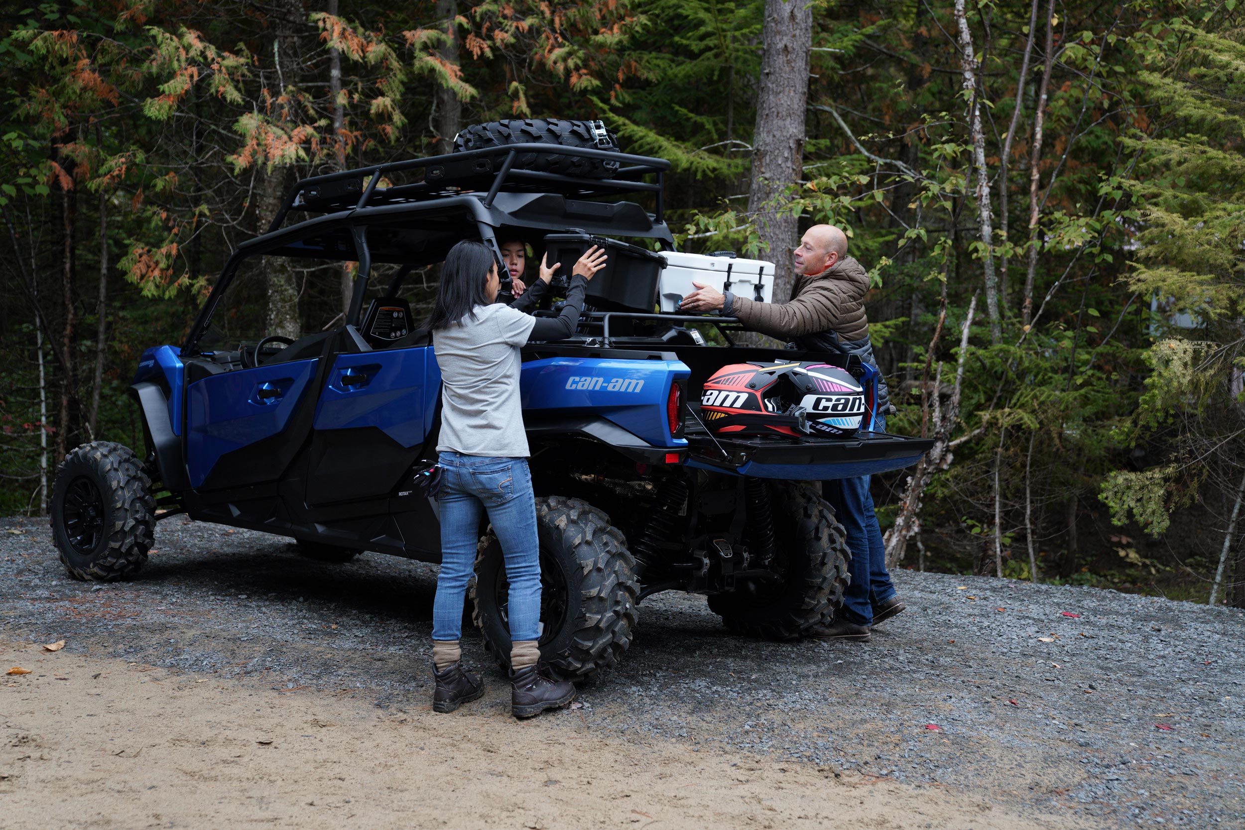 People putting cargo boxes at the back of an accessorized 4-seater Can-Am Commander MAX XT SxS 