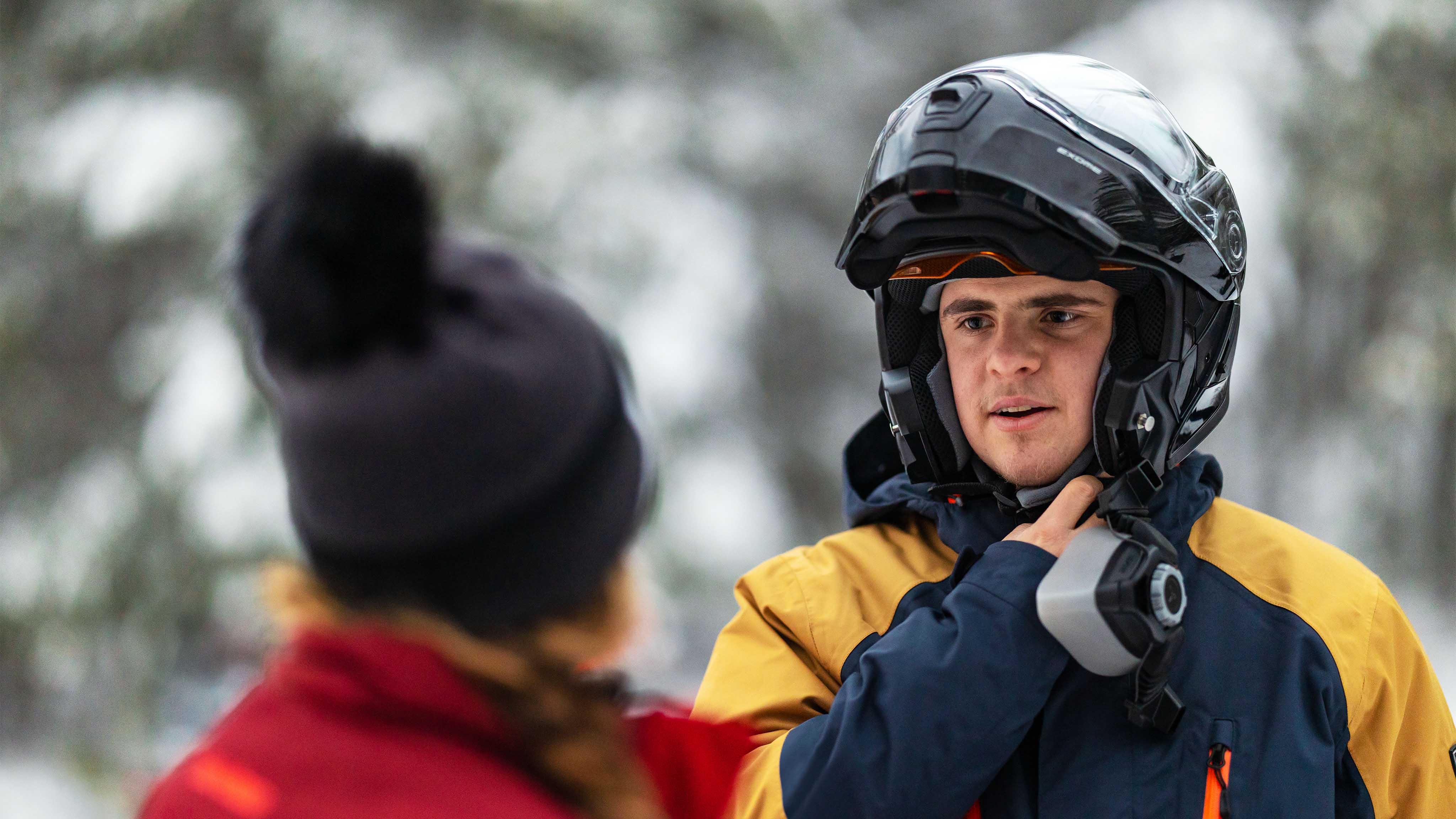 Rider removing his Exome helmet, keeping warm with Can-Am Expedition heated outerwear