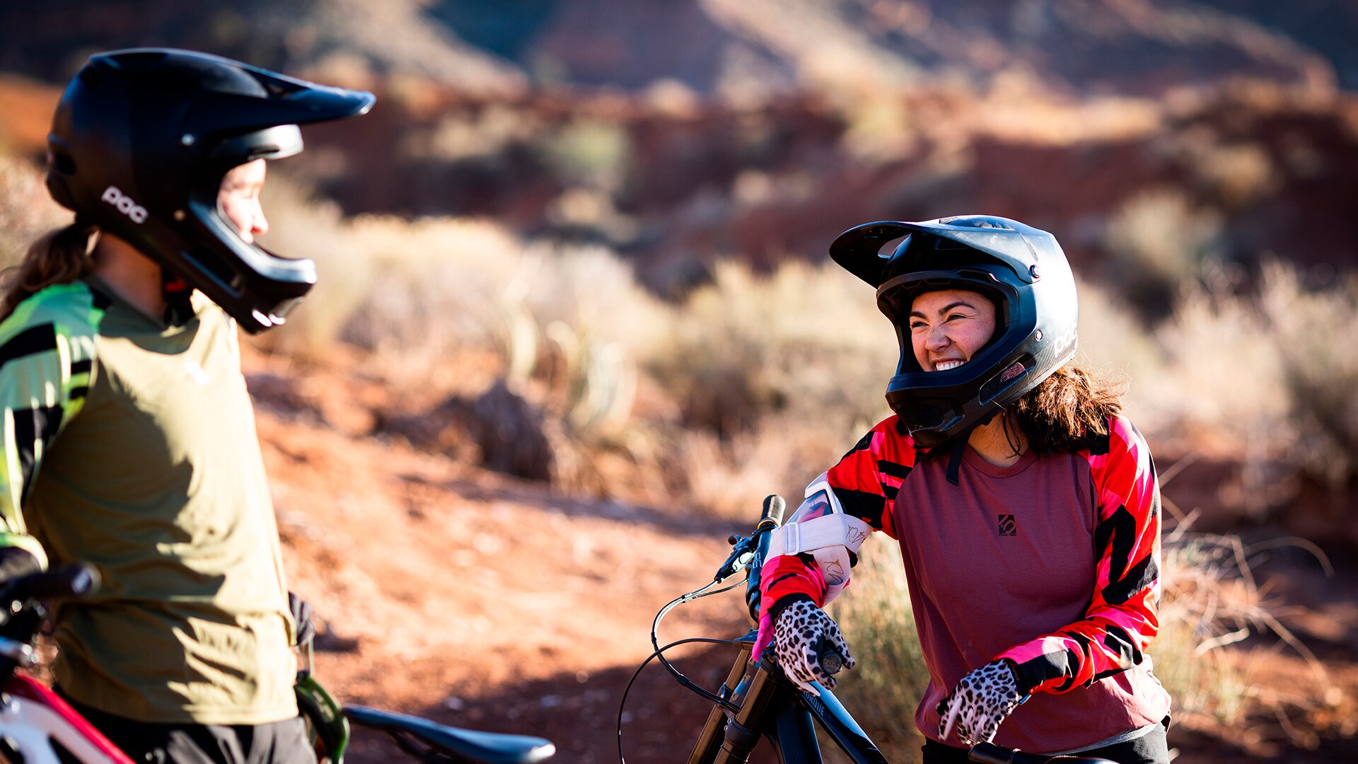 Samantha Soriano souriante, portant un casque Can-Am noir et un chandail rouge et pourpre, appuyée sur une bicyclette