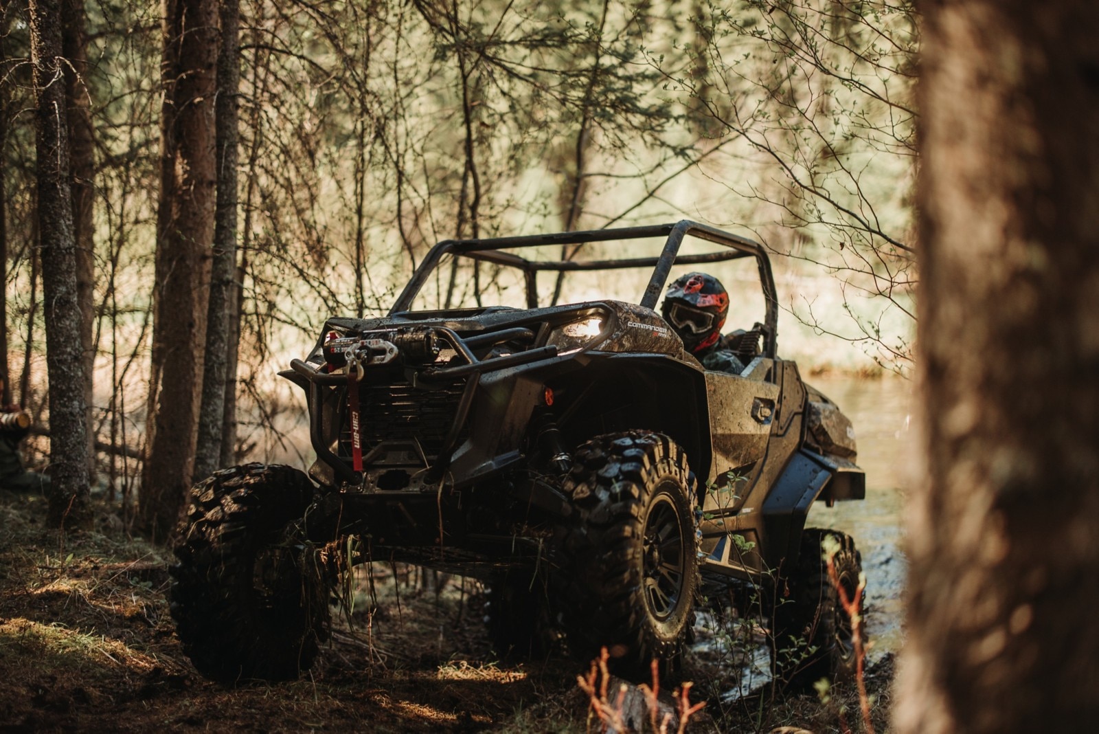 SxS with rider on dirt trail in woods