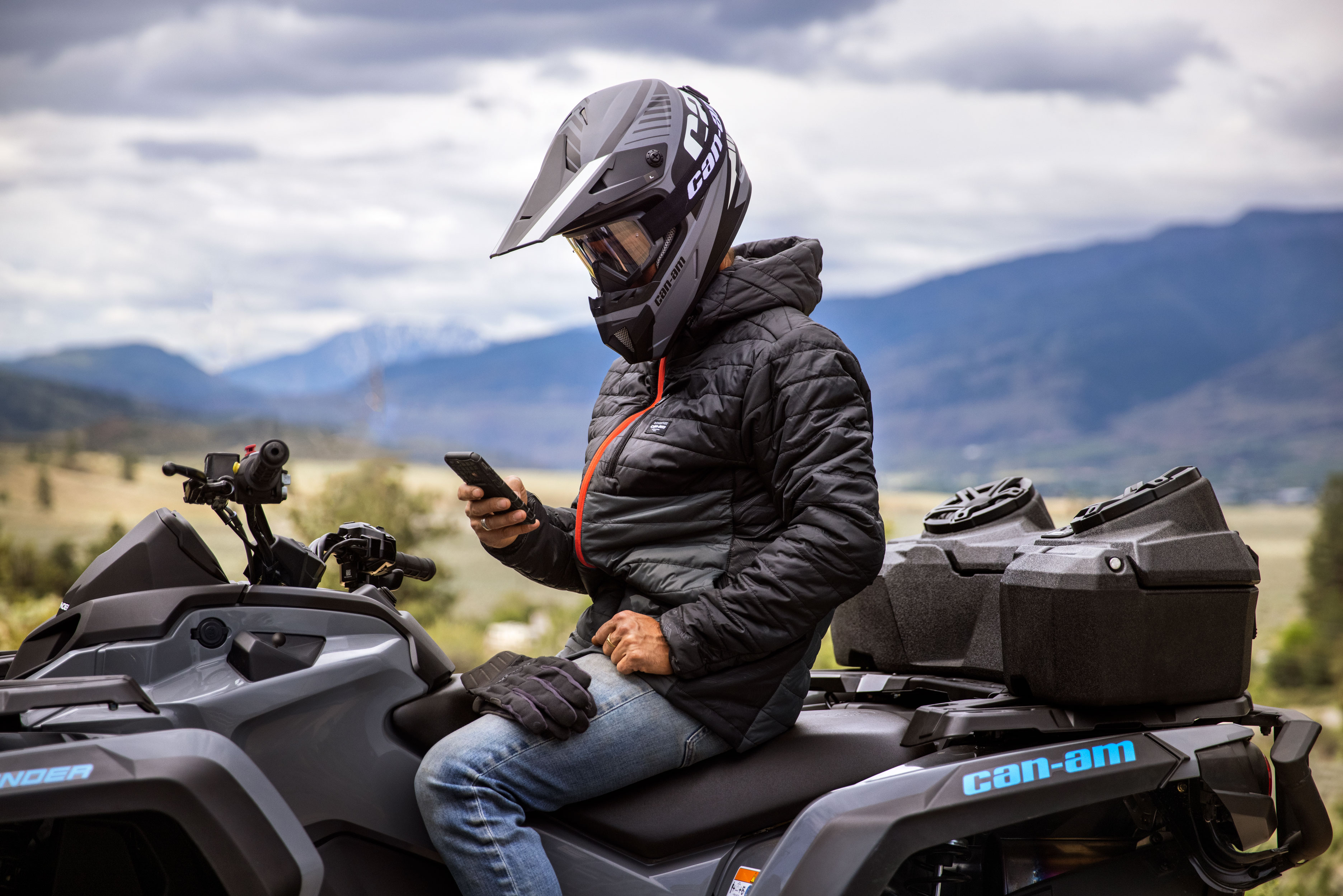 A man with his phone on an ATV