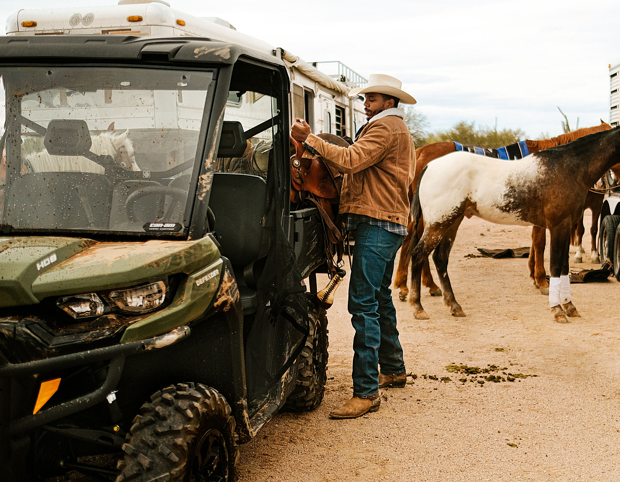 Un hombre con su vehículo Can-Am y un caballo