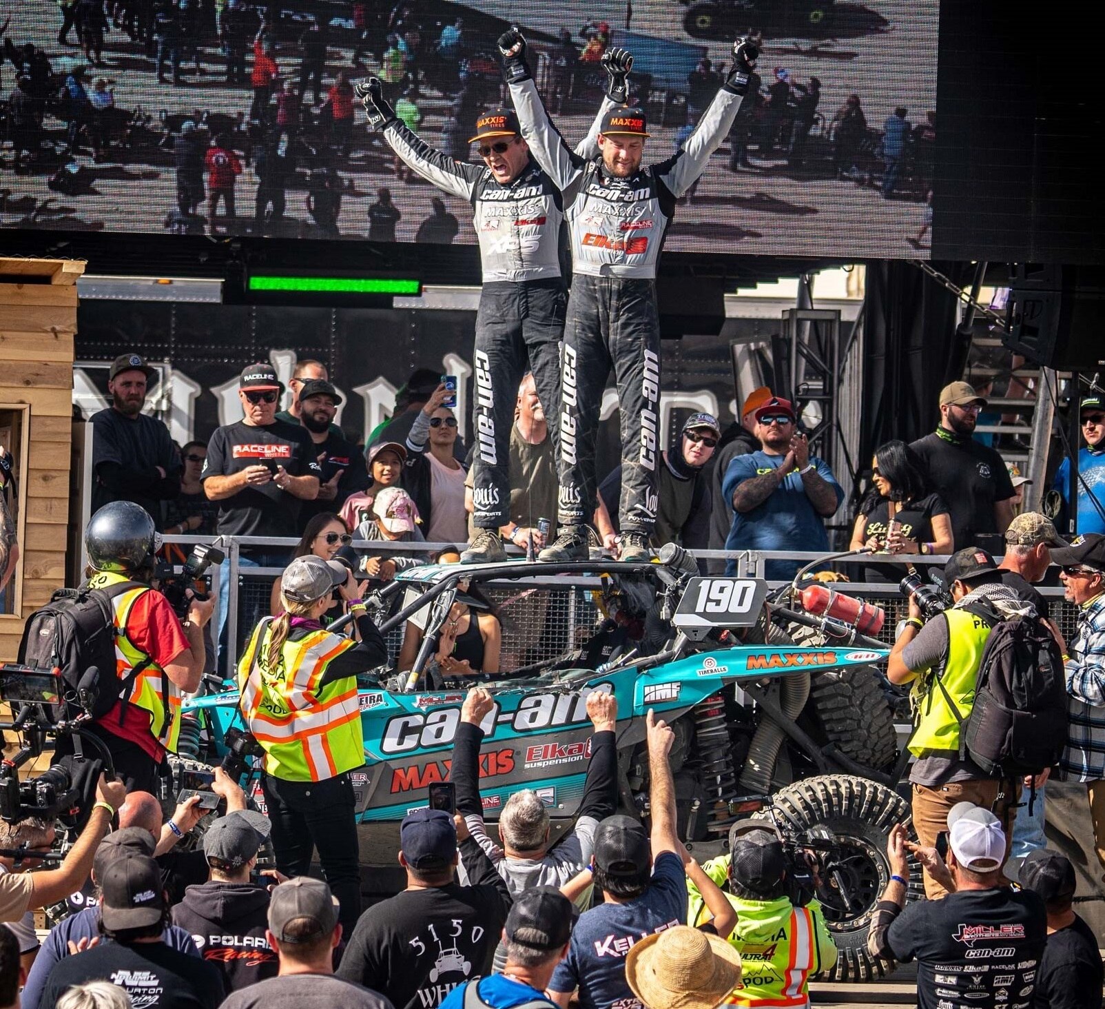 Can-Am racers standing on top of their Maverick X3 after sweeping the podium at the King of Hammers race. 
