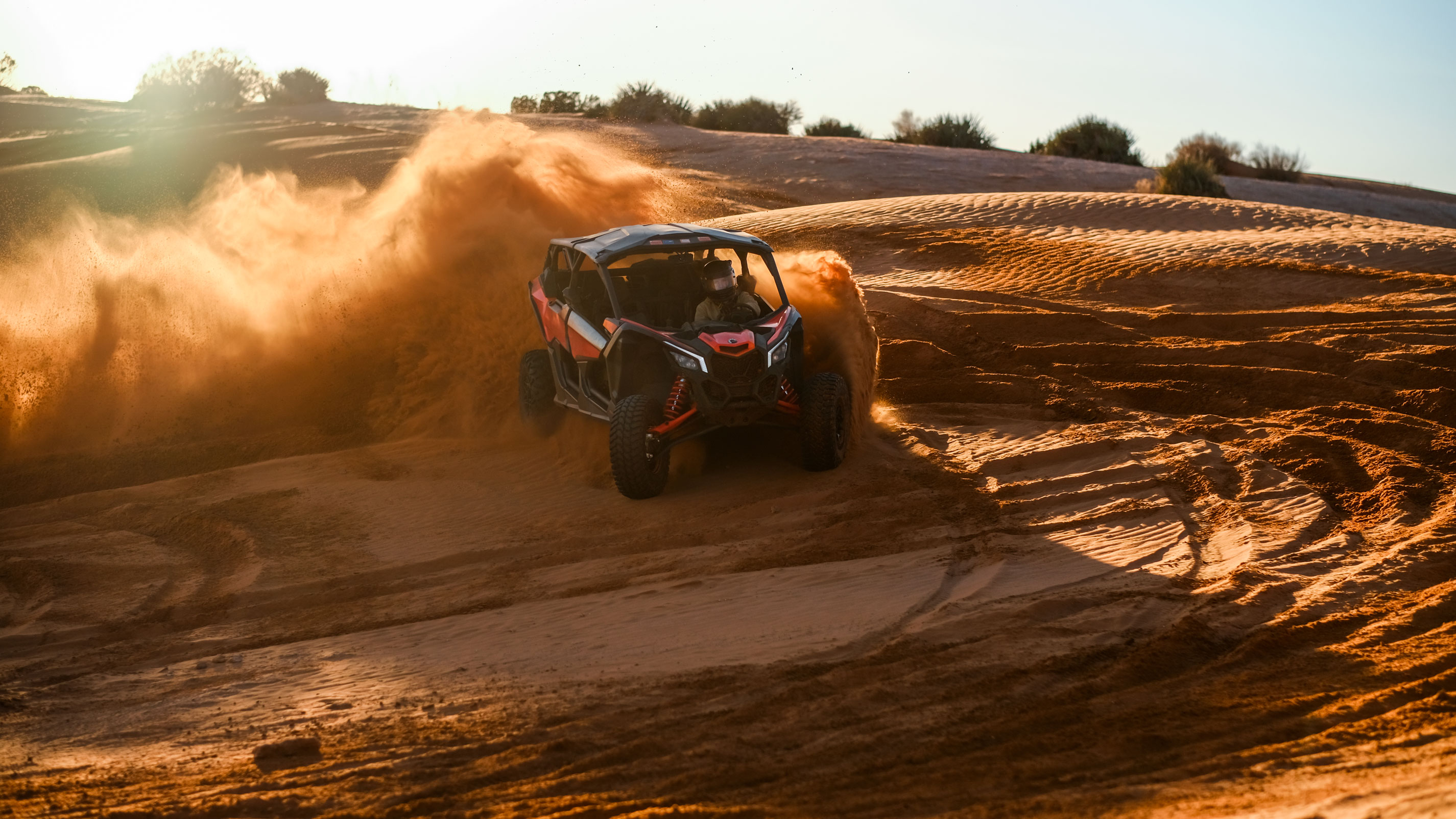 Can-Am SxS vehicles on dunes at dusk