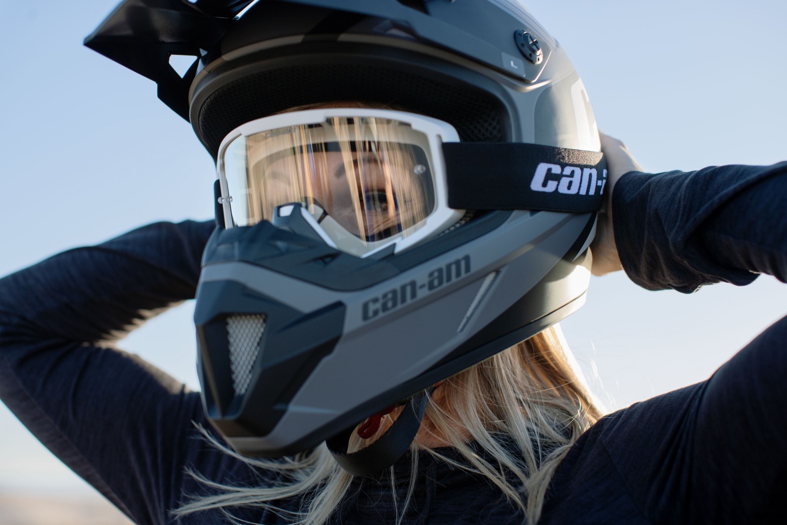 Woman adjusting Can-Am Googles on helmet
