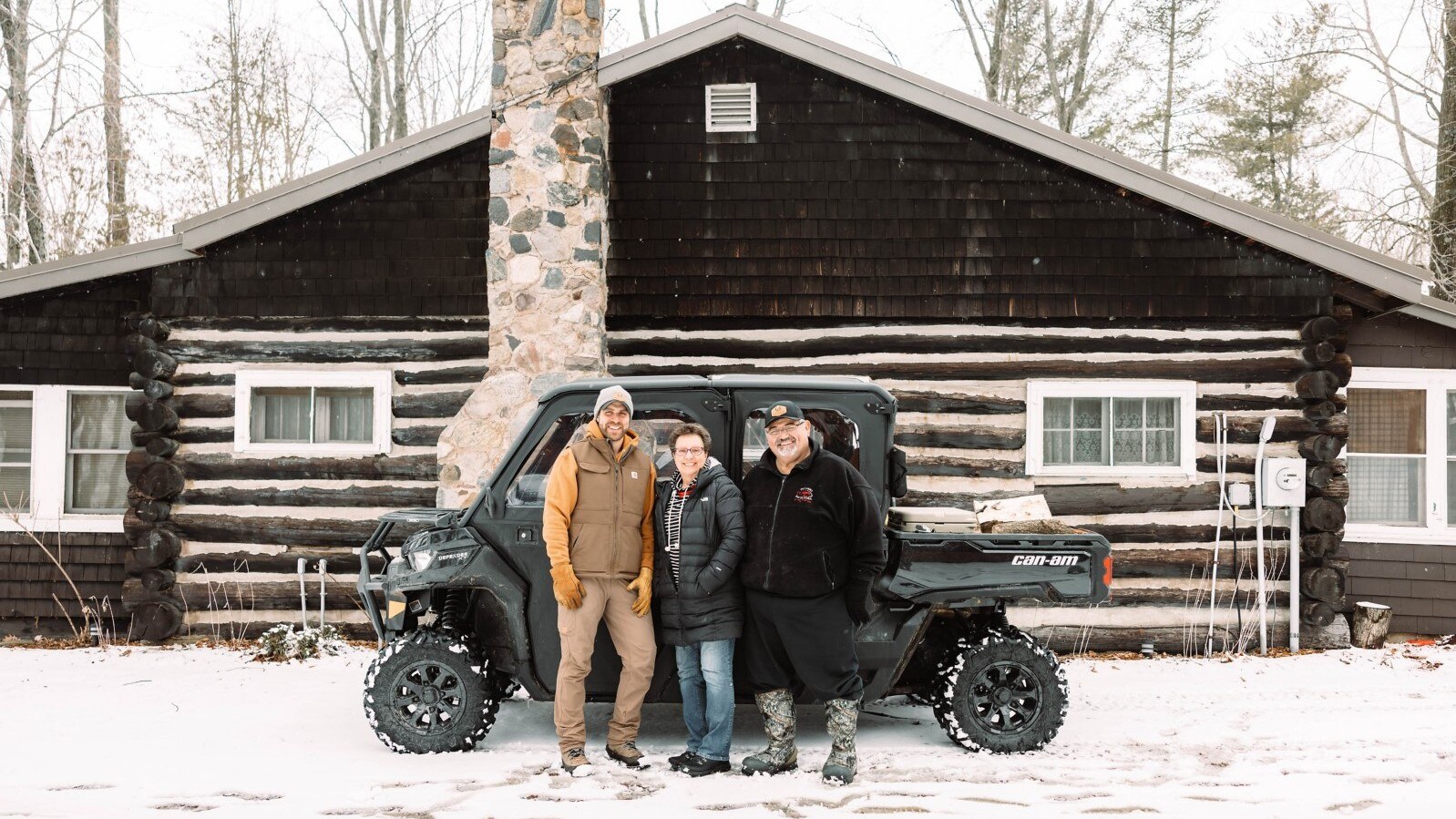 Brett Smith and his parents posing in front of their Can-Am Defender parked in front of their home. 