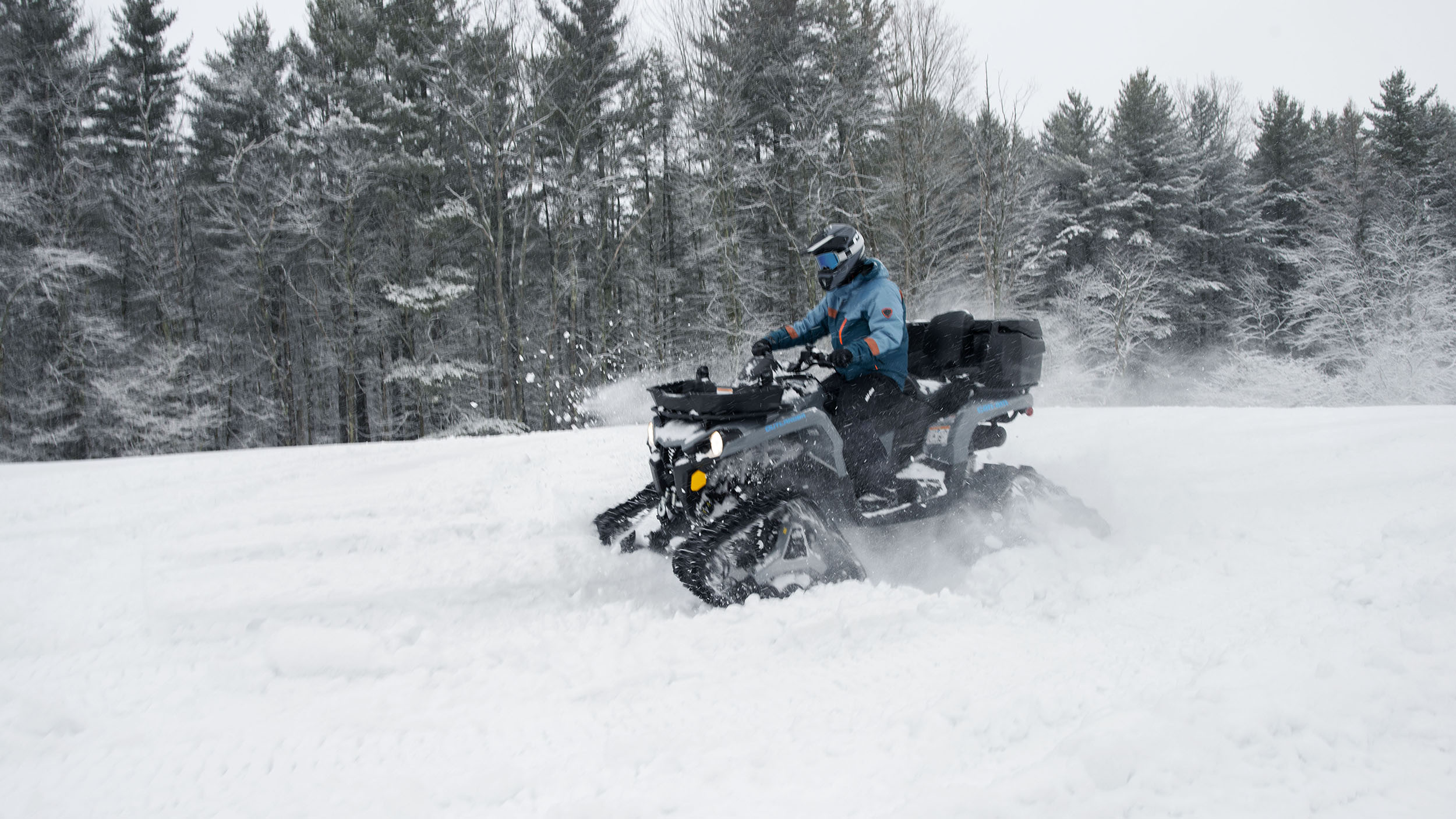 A Can-Am rider speeding by in the snow