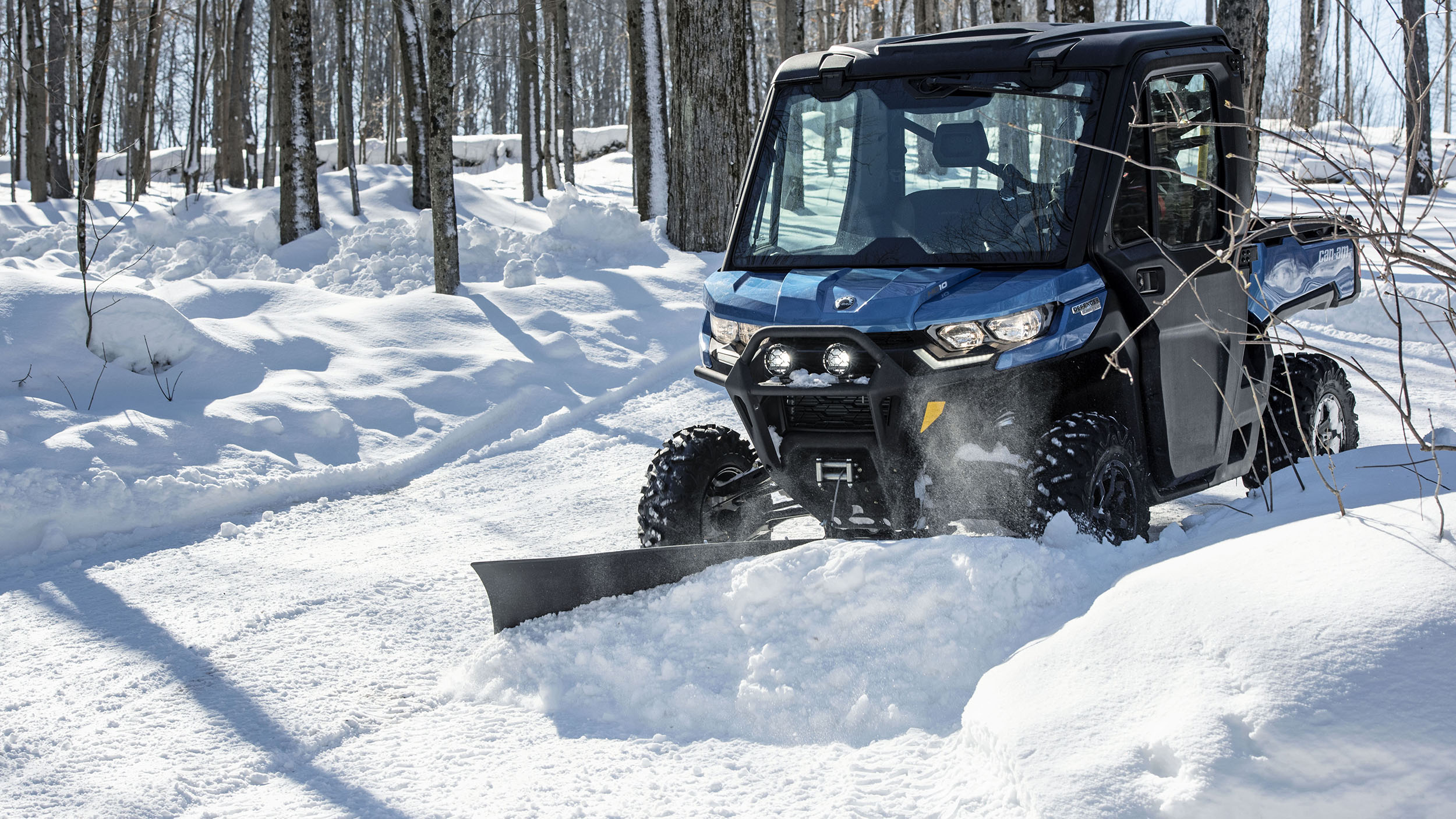 A Can-Am Defender plowing snow
