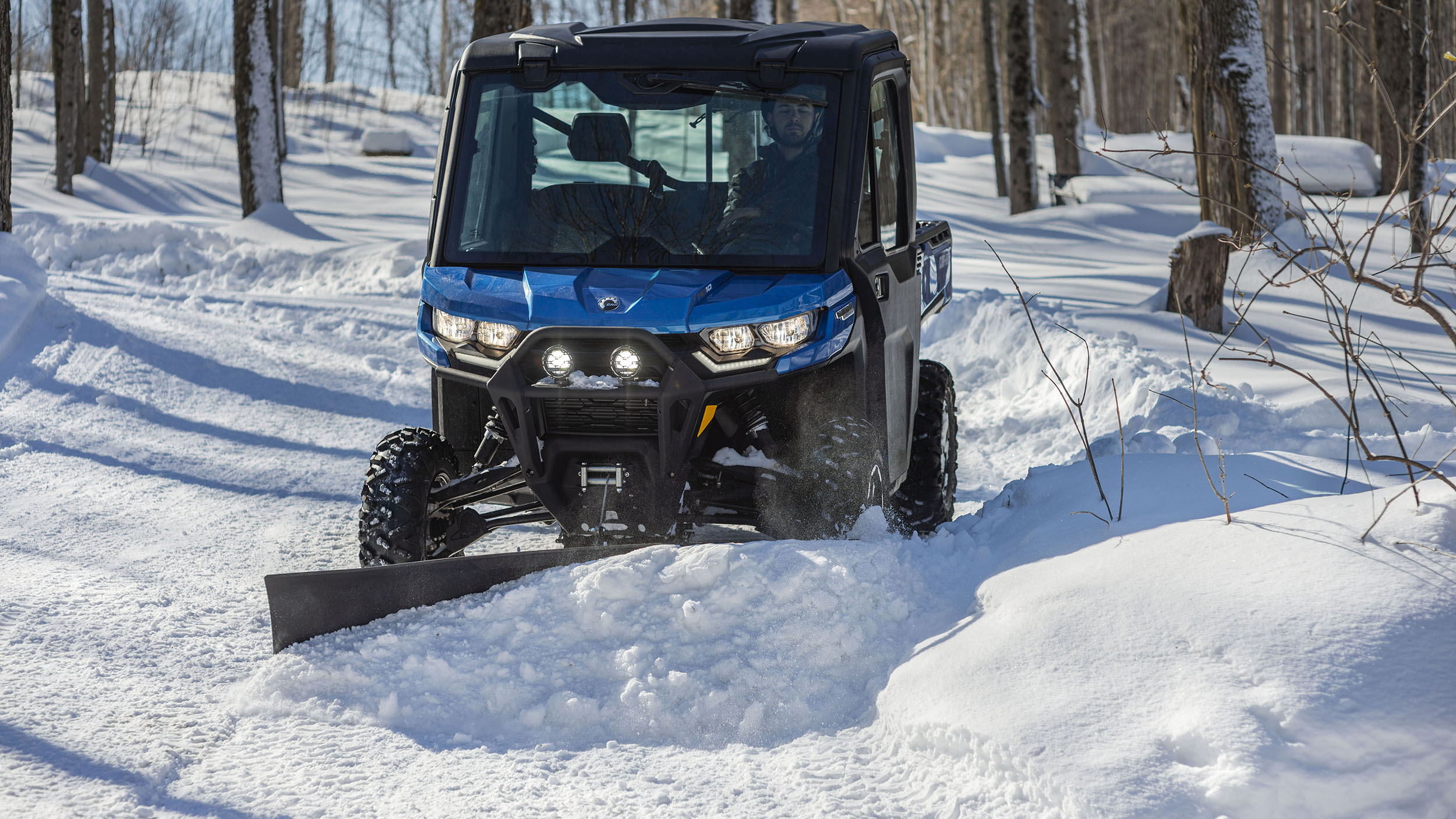 A Can-Am Defender plowing snow