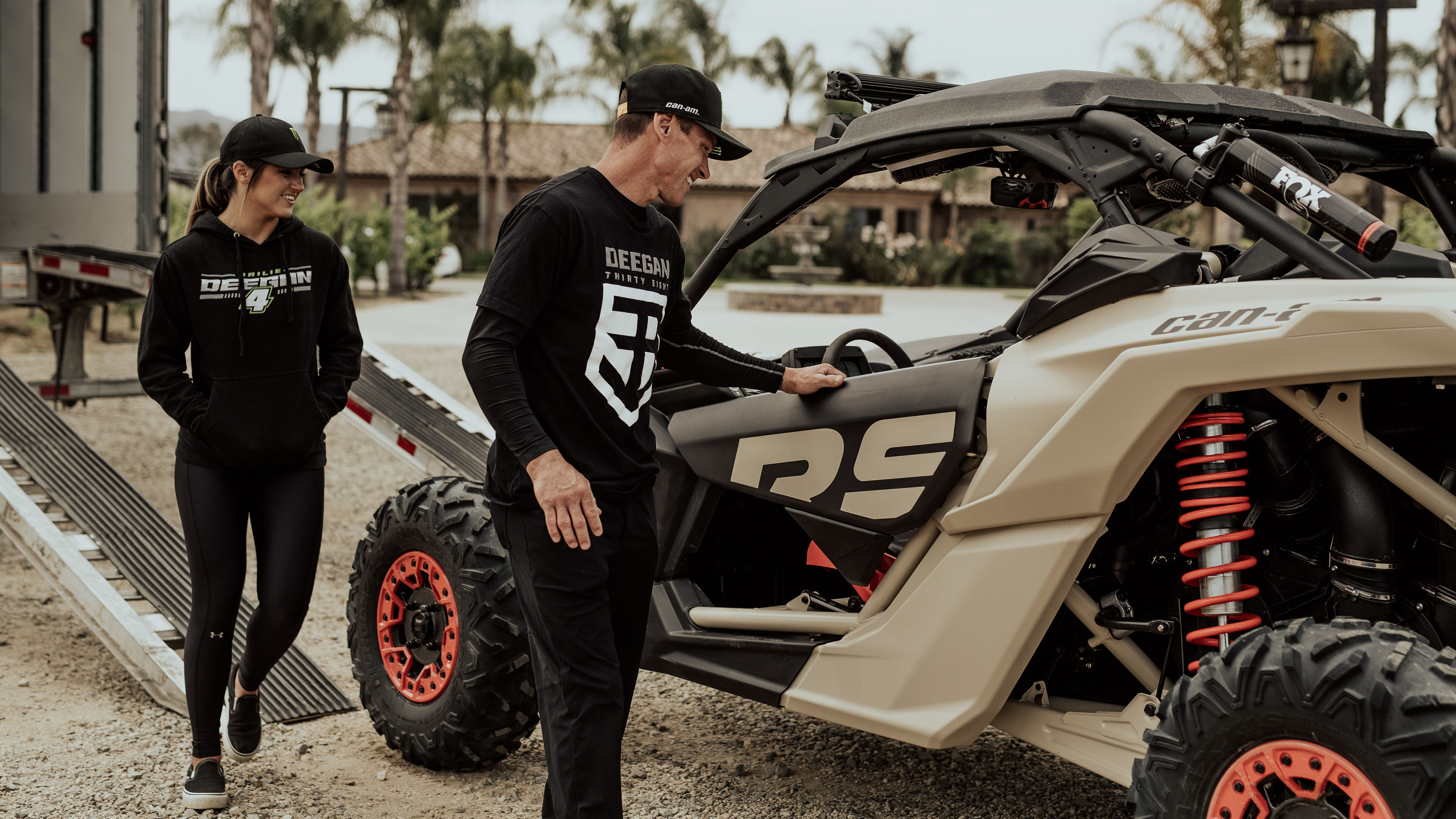 2 riders beside Can-Am Off-Road vehicle