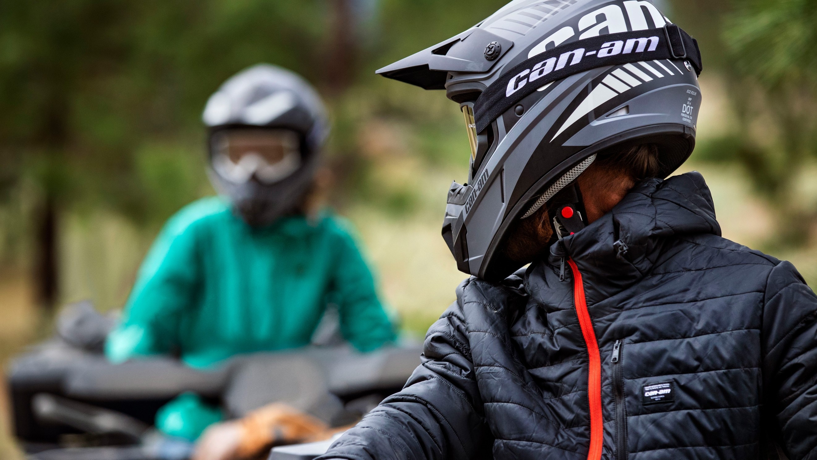 2 Personen mit Can-Am-Helmen unterhalten sich während einer ATV-Fahrt