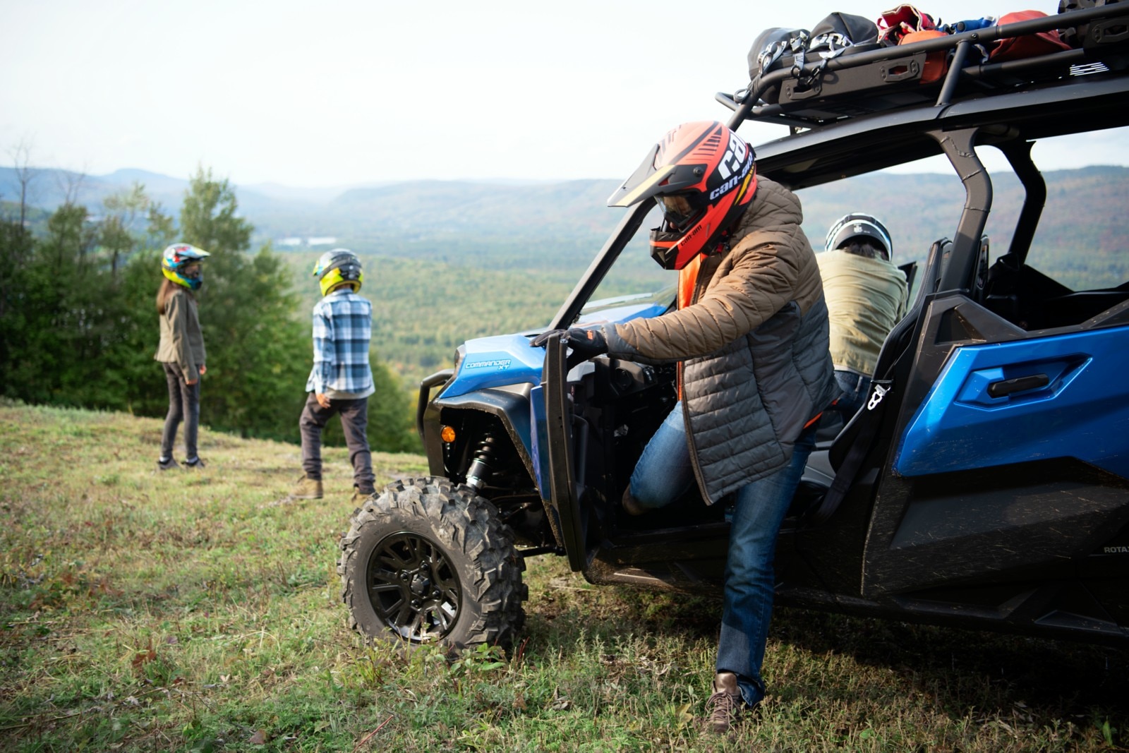 A man stepping out of his Can-Am Commander XT while on an adventure with his family
