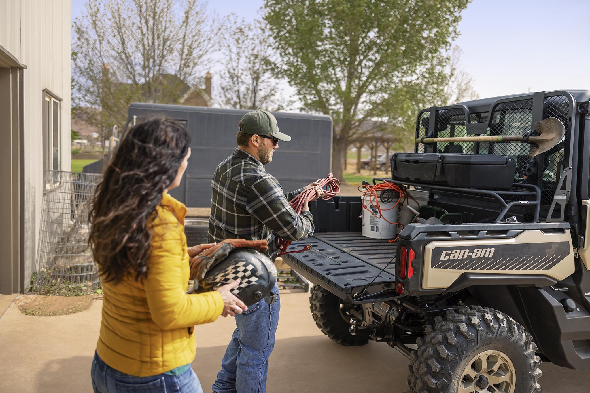 Man and woman load cargo on their Can-Am Defender