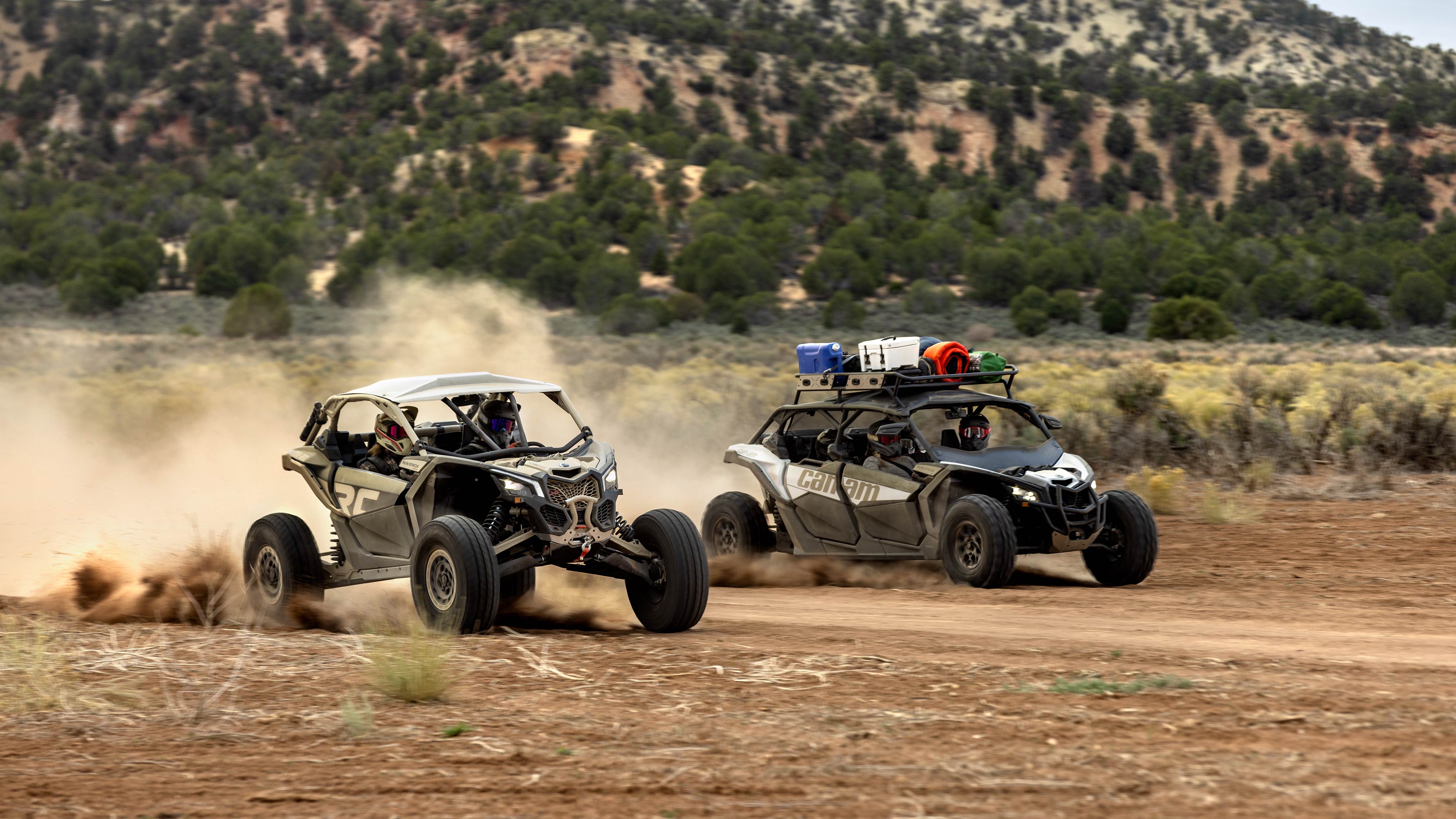 A Mineral Grey and Desert Tan Can-Am Maverick X3 RC 72 Turbo RR and a Catalyst Grey Maverick X3 MAX DS Turbo in a desert setting