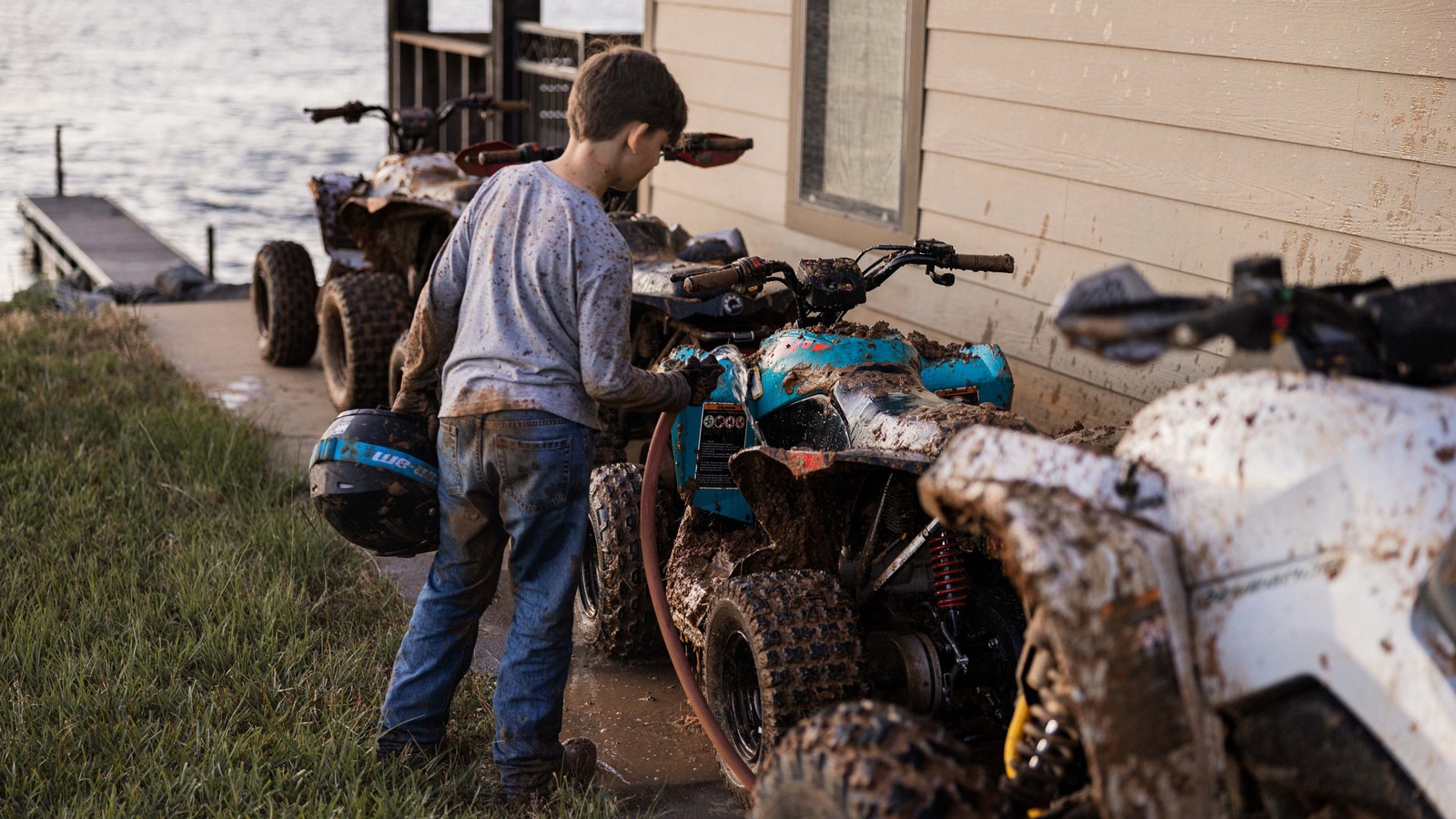 Young boy and muddy ATVs