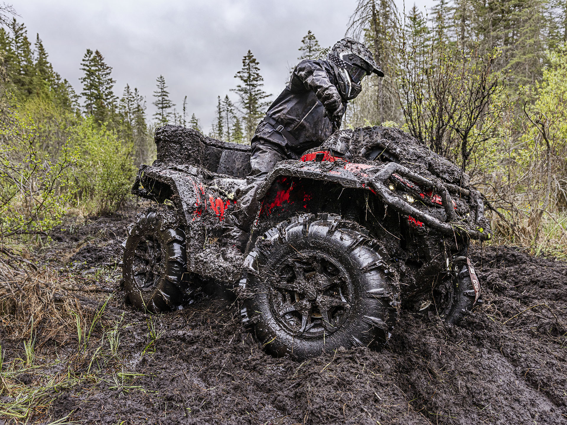2024 Can-Am Outlander X MR ATV riding in the mud