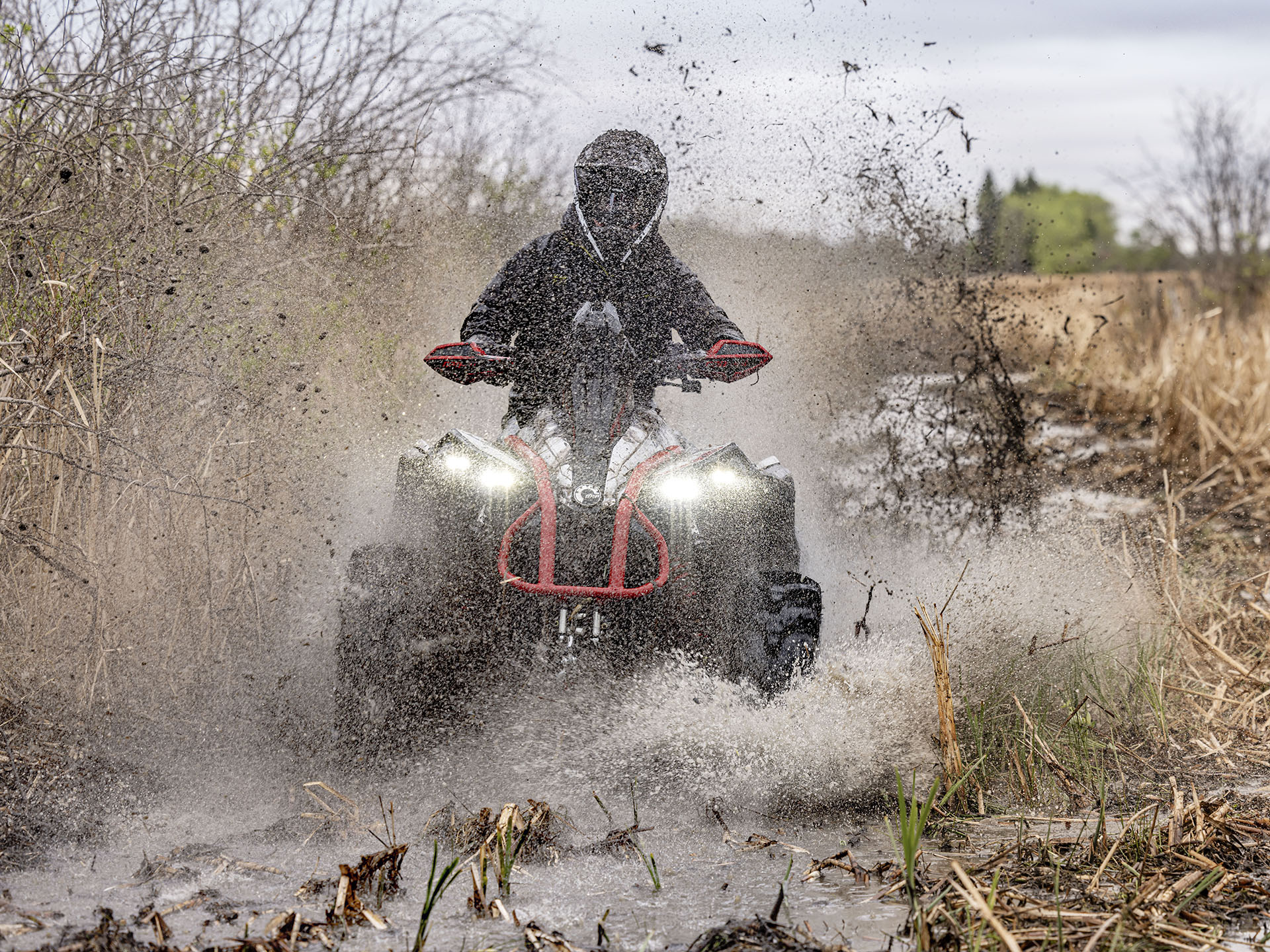 Rider driving a 2024 Can-Am Renegade X MR ATV in deep mud