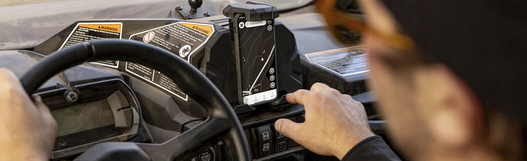 Motociclista utilizando el BRP GO! en un teléfono móvil colocado en un soporte para teléfono