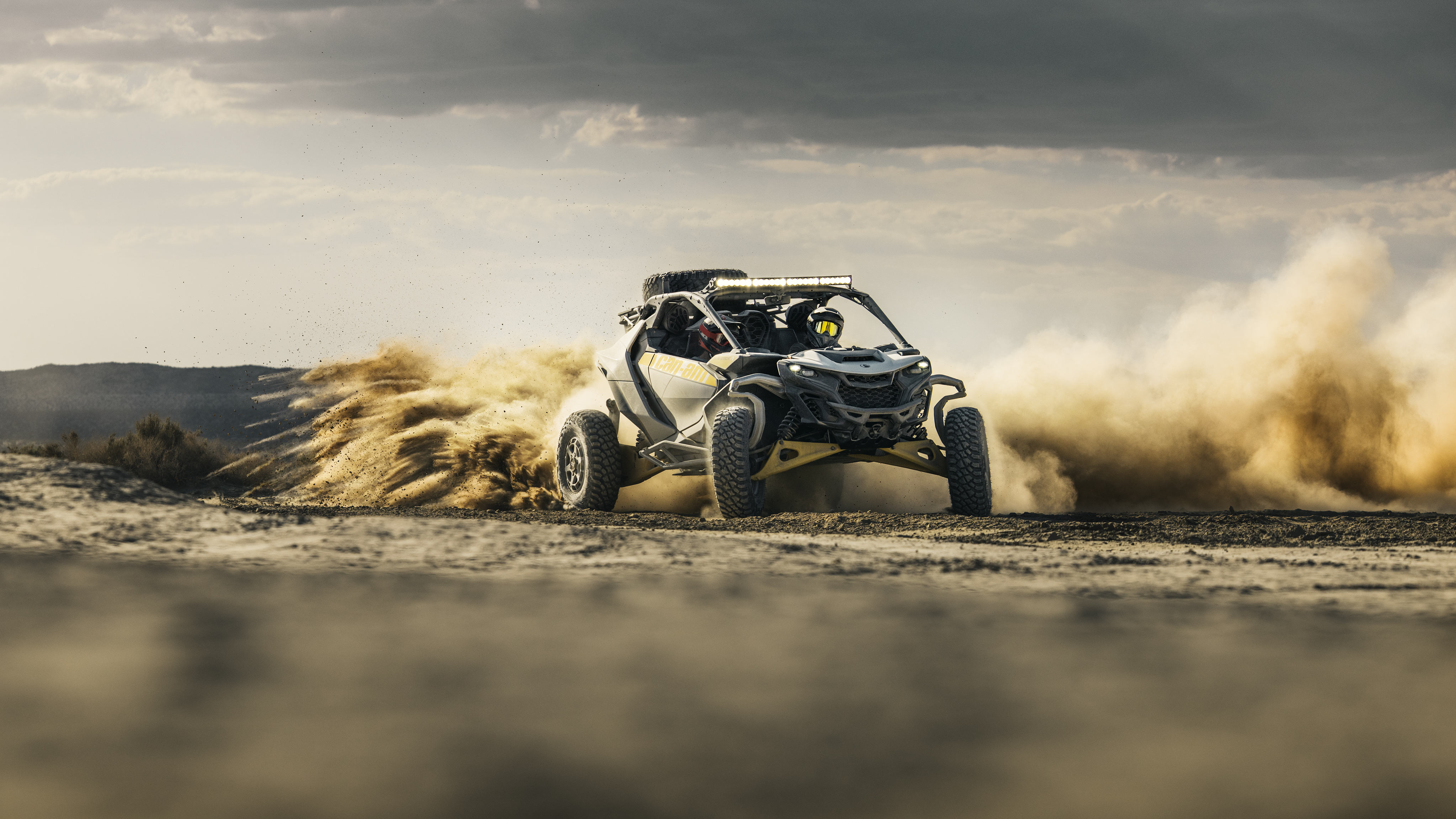 A Can-Am Maverick R driving fast in the desert