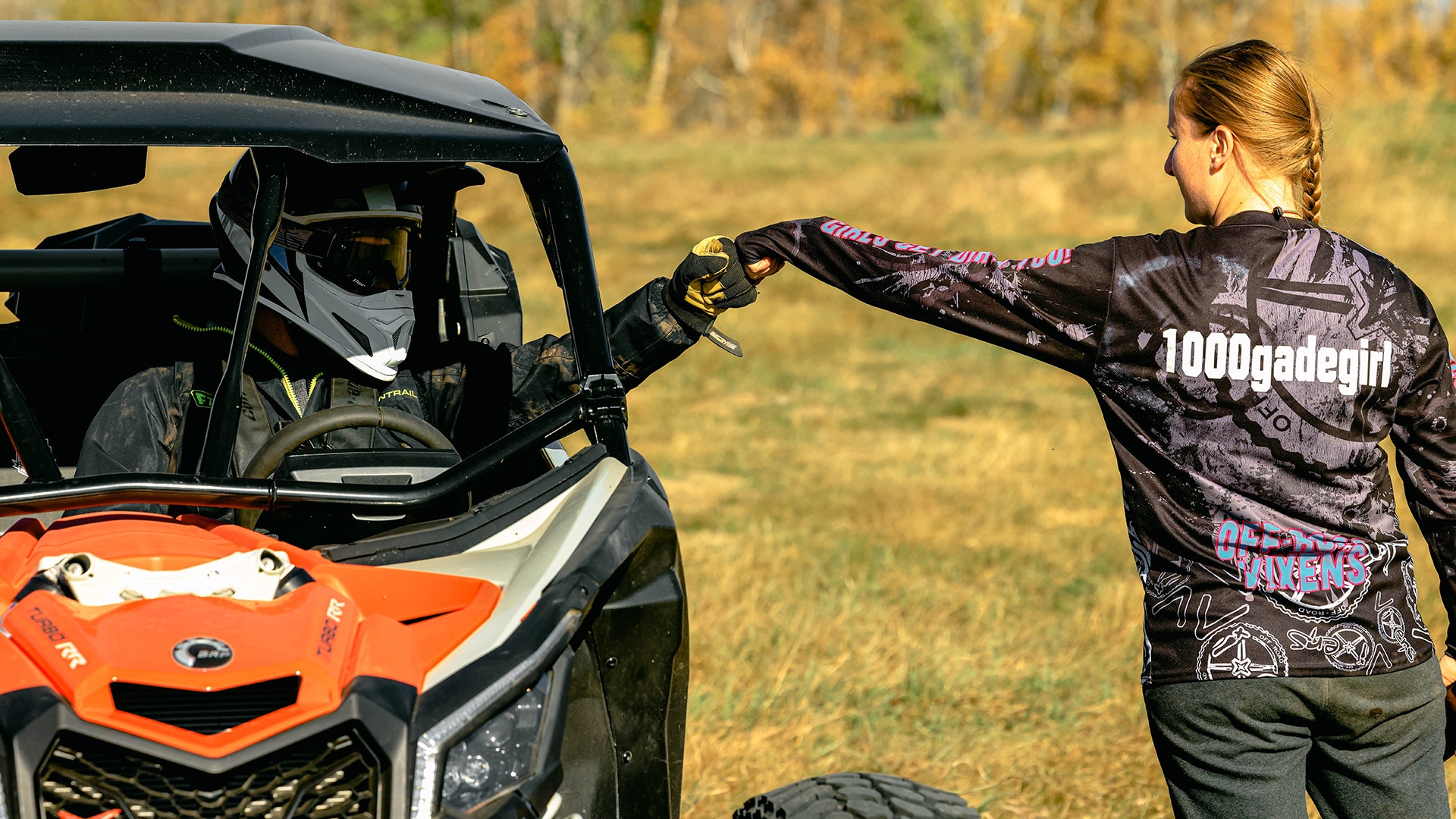 Two Can-Am off-road rider fist bumping
