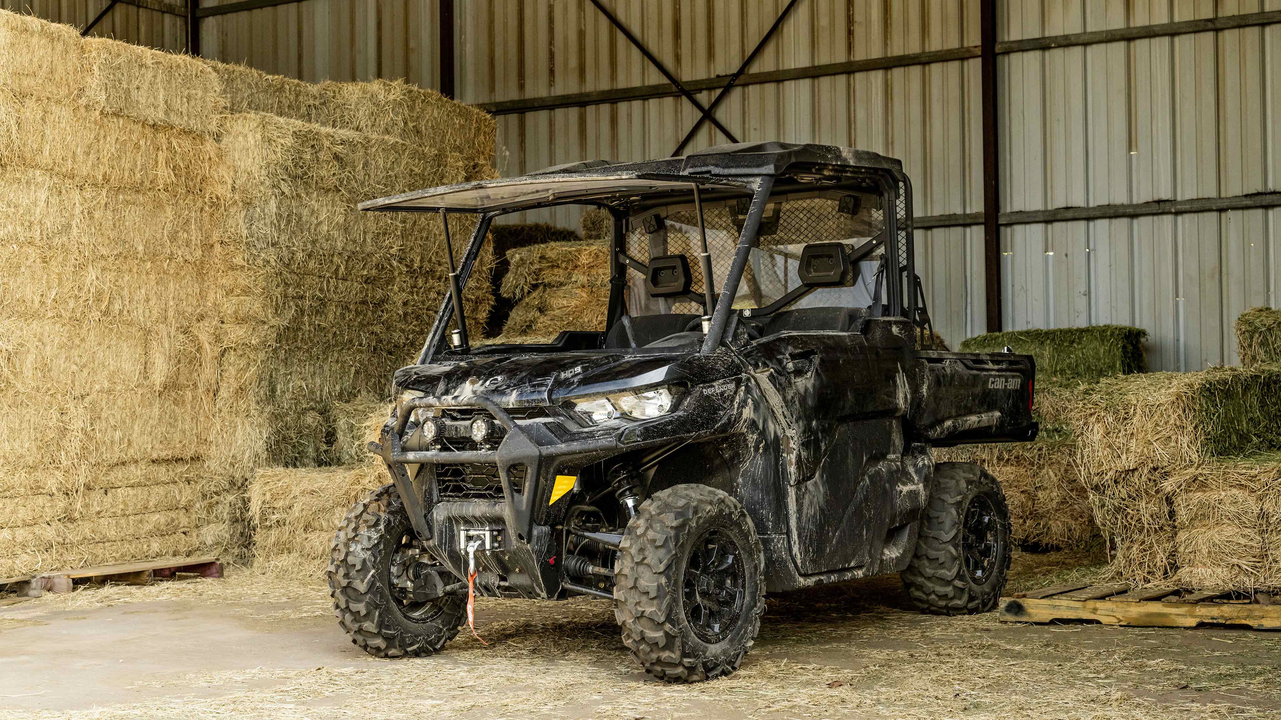A Can-Am Defender SSV parked in a barn